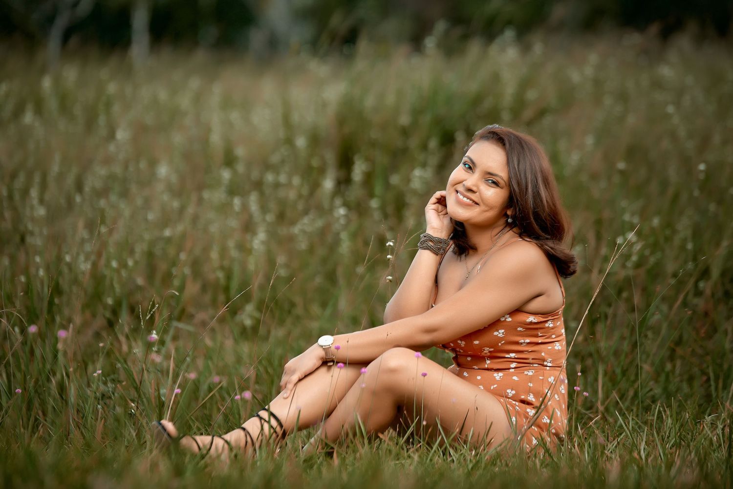 Artistic outdoor portrait session in a grassy field during golden hour.