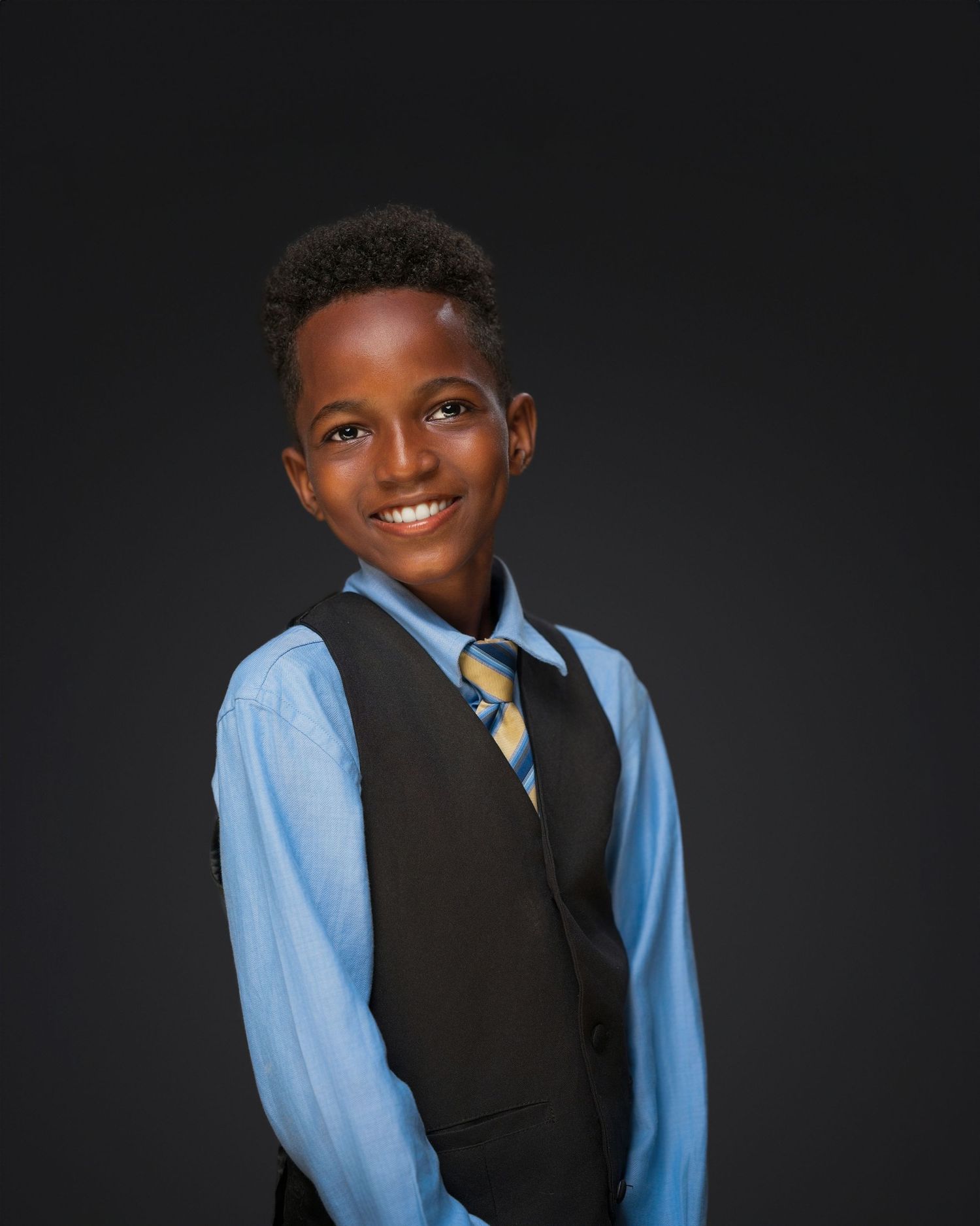 Professional studio portraits with formal attire against dark background.