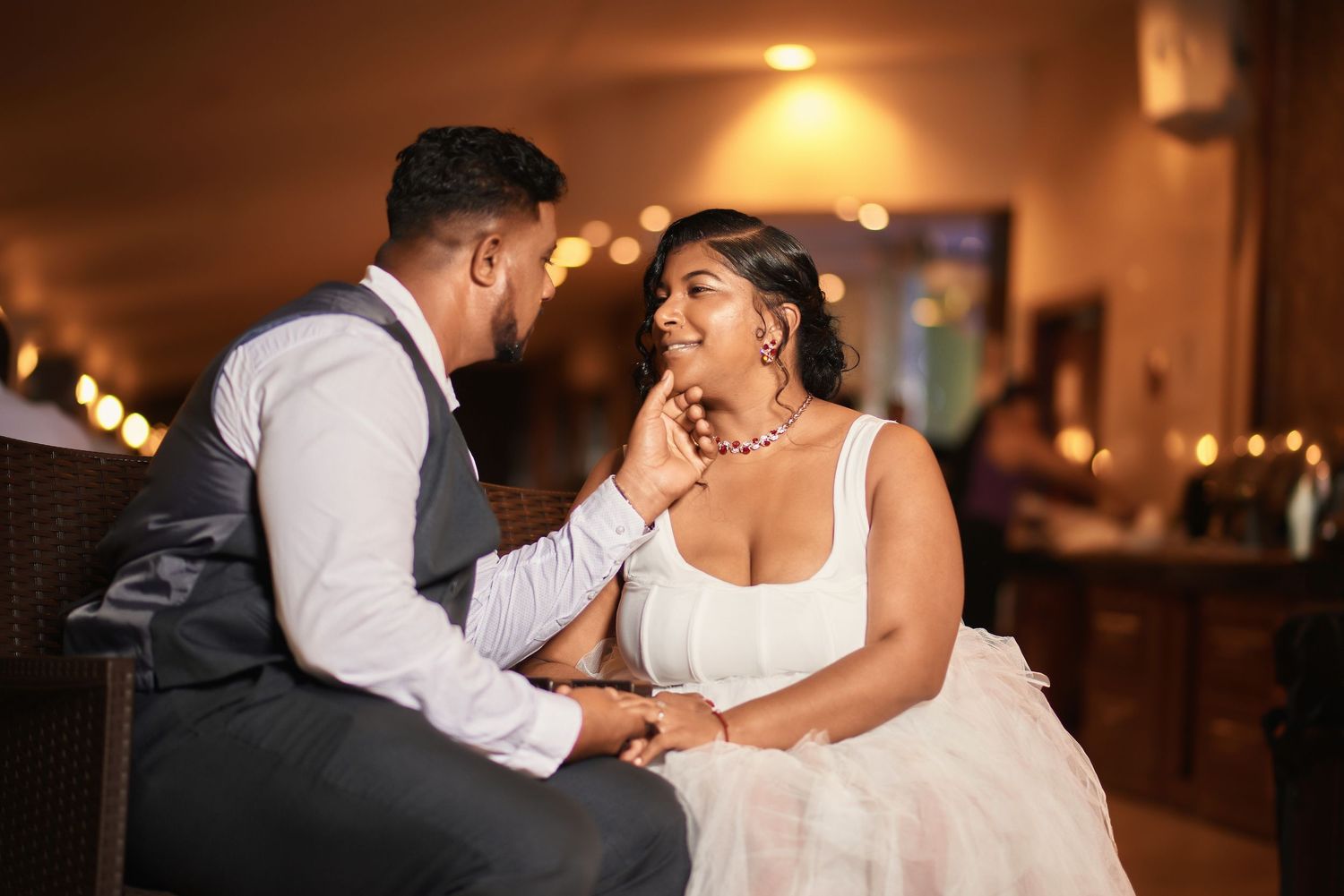 A romantic moment captured in warm lighting at an indoor celebration.