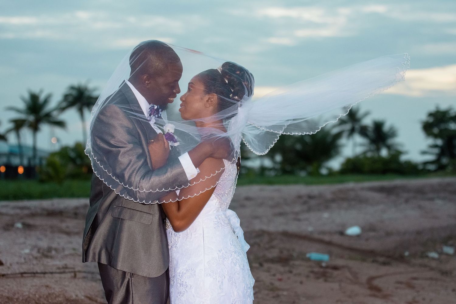 A couple shares an intimate moment during their beach wedding at sunset.