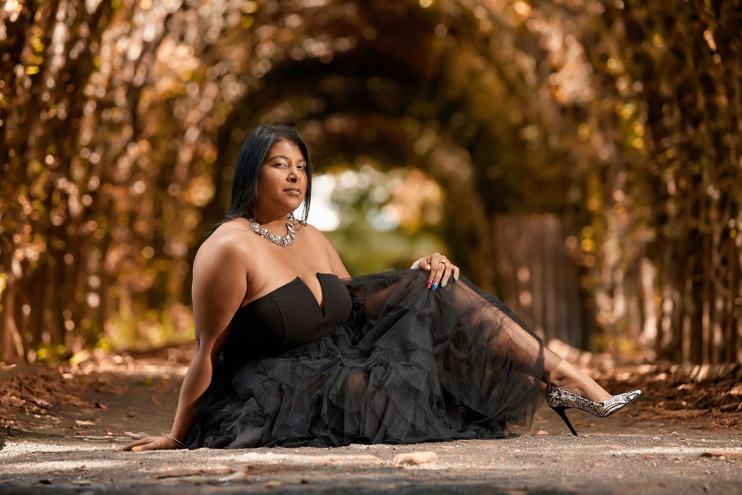 Elegant portrait session featuring a black tulle dress in a warm autumn setting.