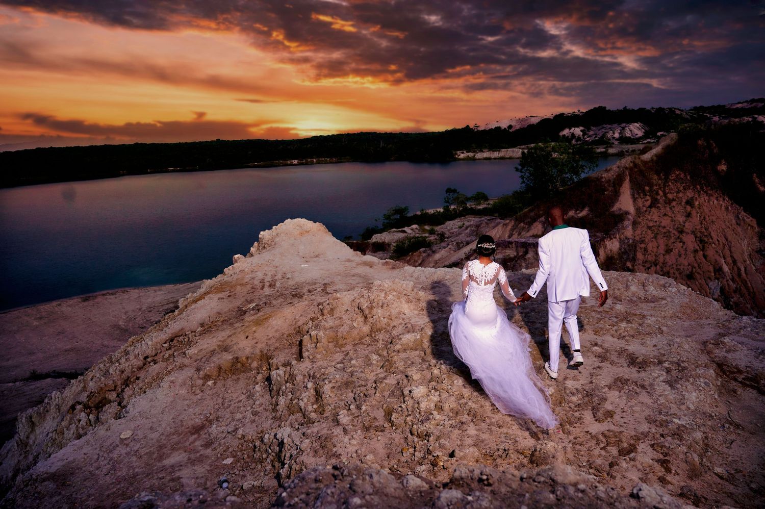 Stunning coastal wedding photography during golden hour with dramatic rock formations.