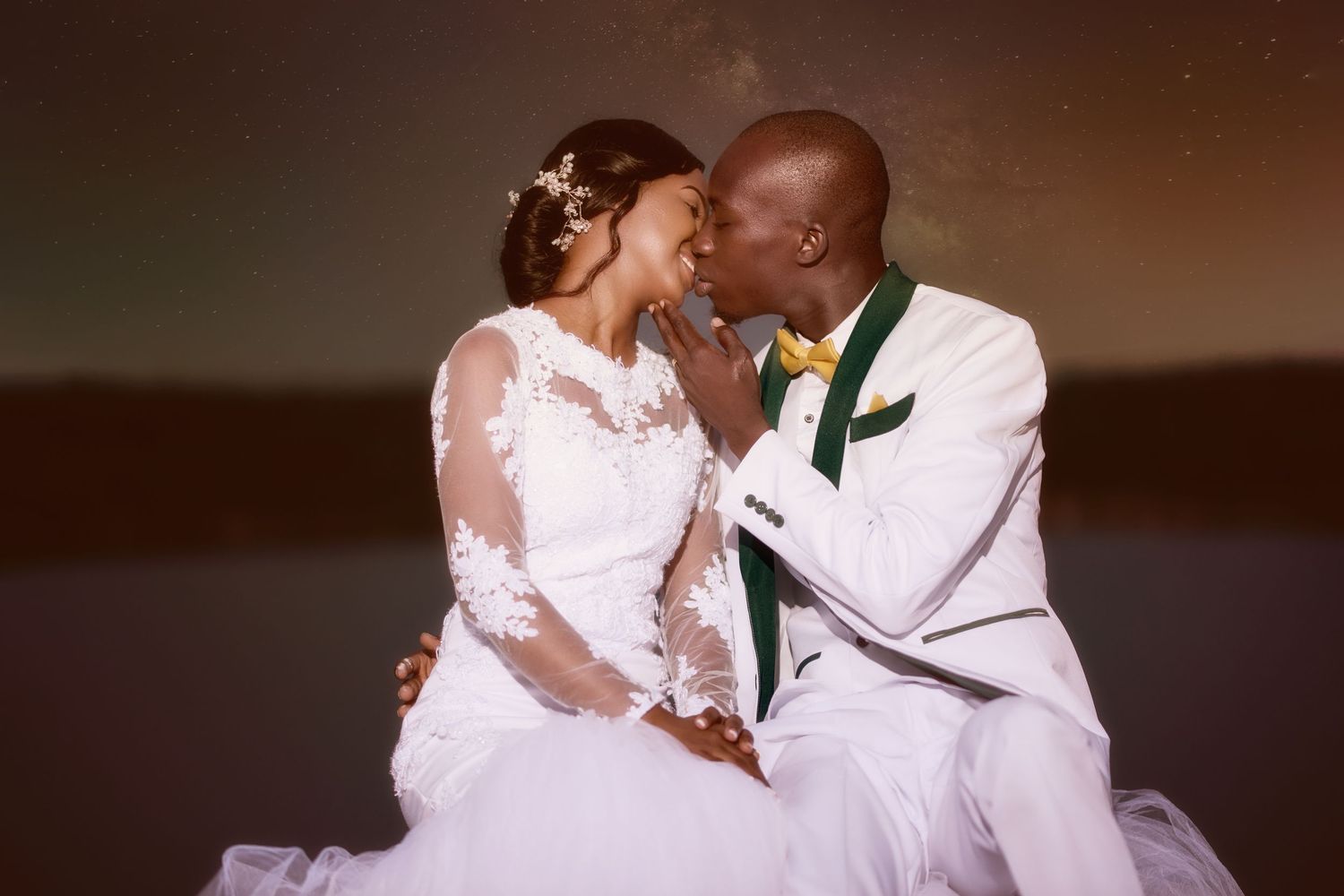 Wedding couple in white attire shares intimate moment during portrait session.