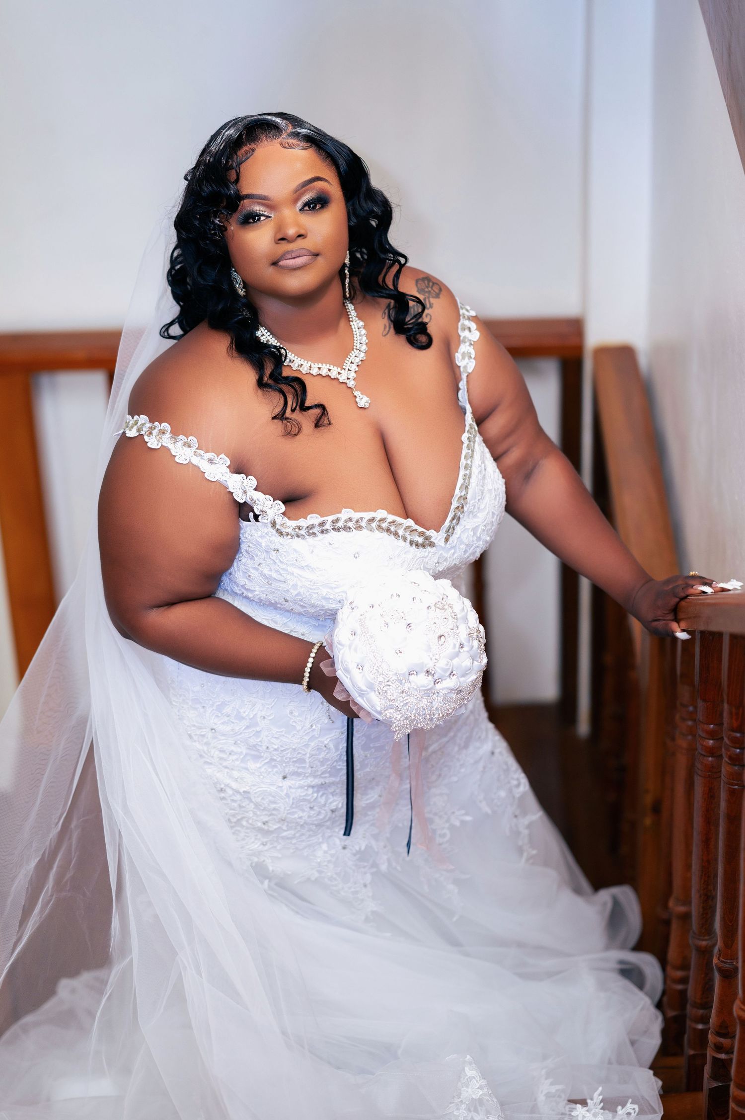 Bride in white lace wedding dress posing for bridal portraits.