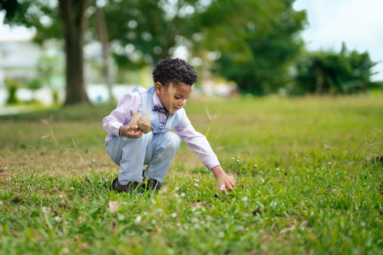 Child exploring and crawling through green grass outdoors.