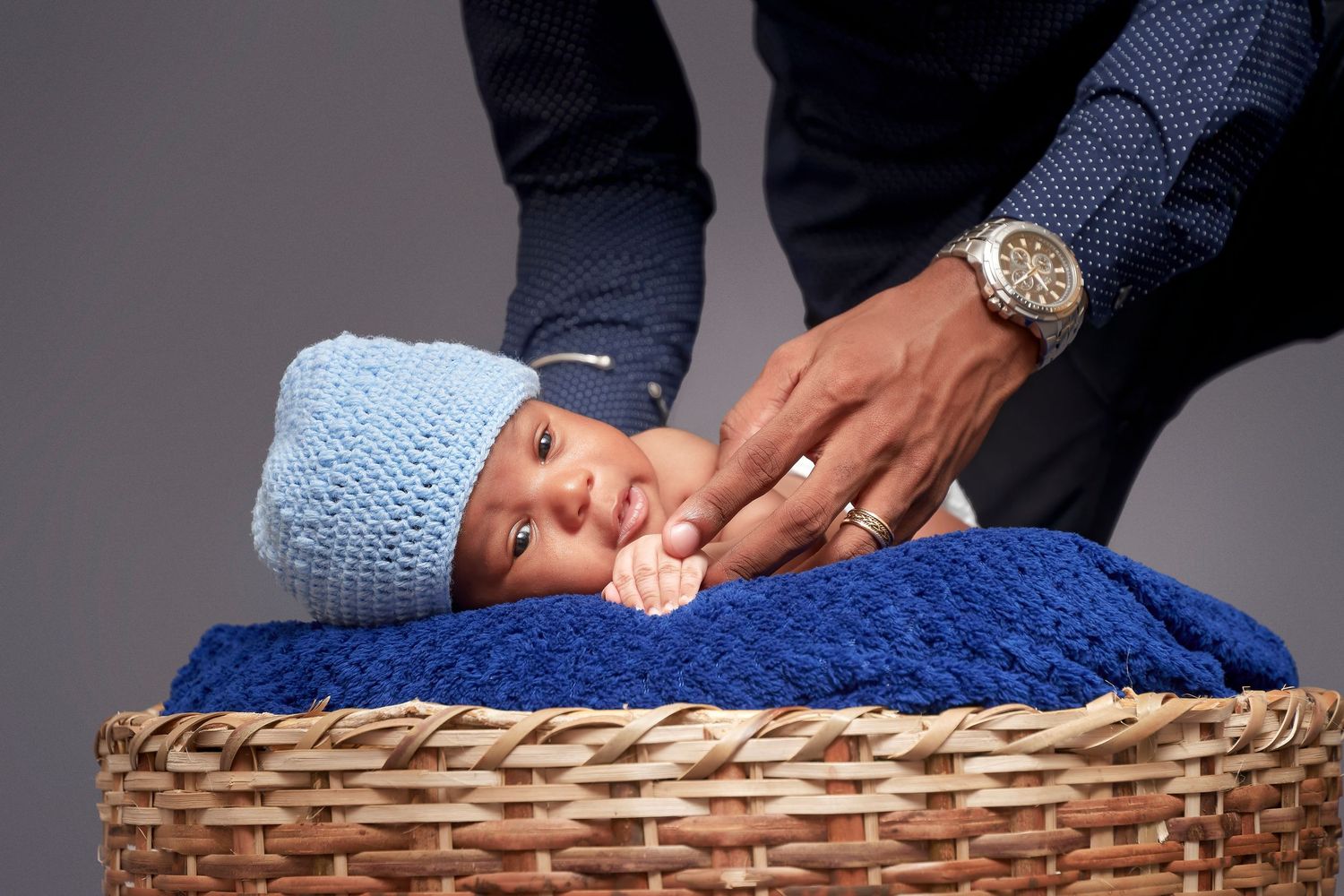 A series of photos showing a baby being placed in a woven basket for a newborn photography session.