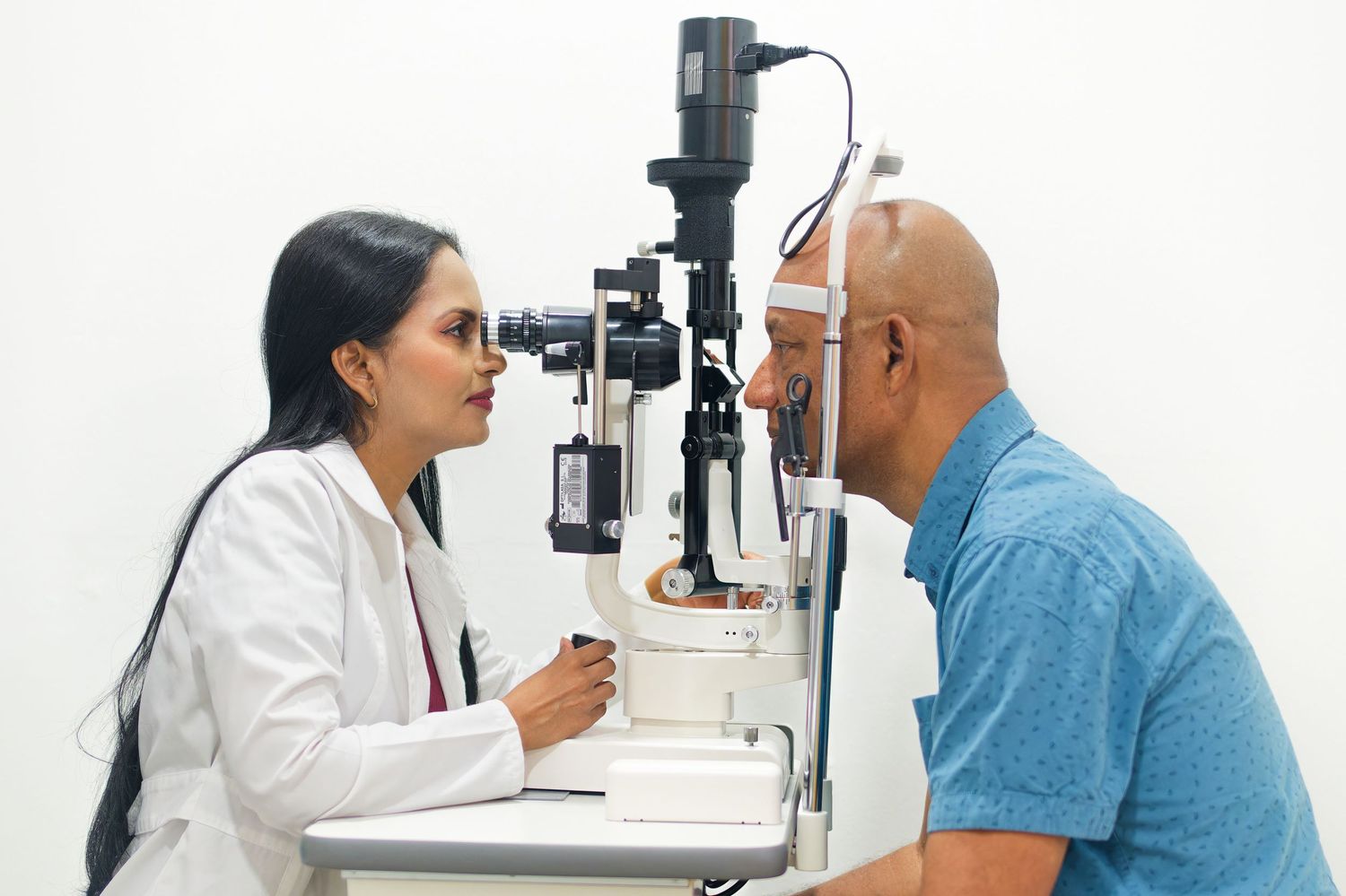 Eye doctor performing vision examination with specialized optometry equipment.