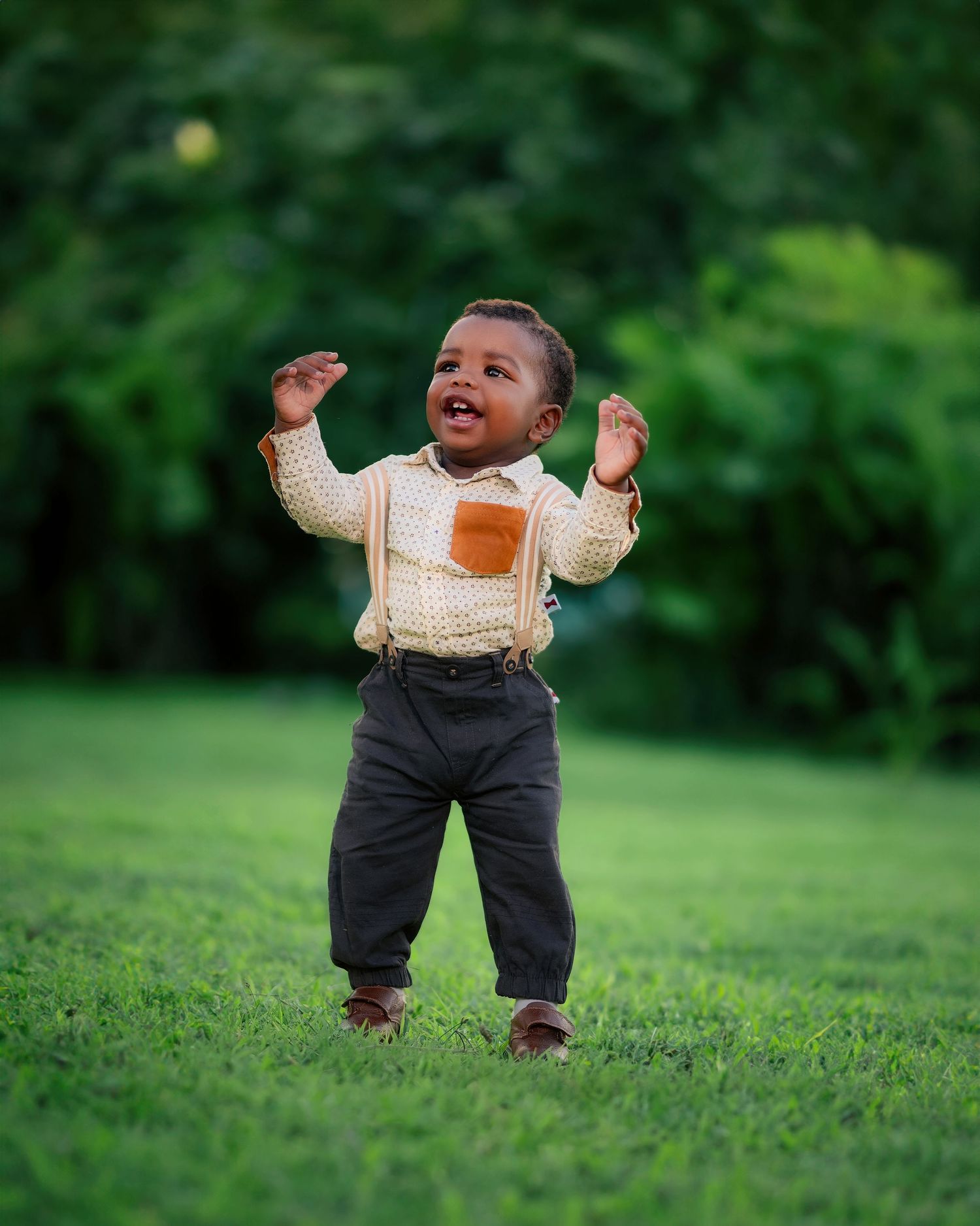 Child in cream top and dark pants playing on green lawn.