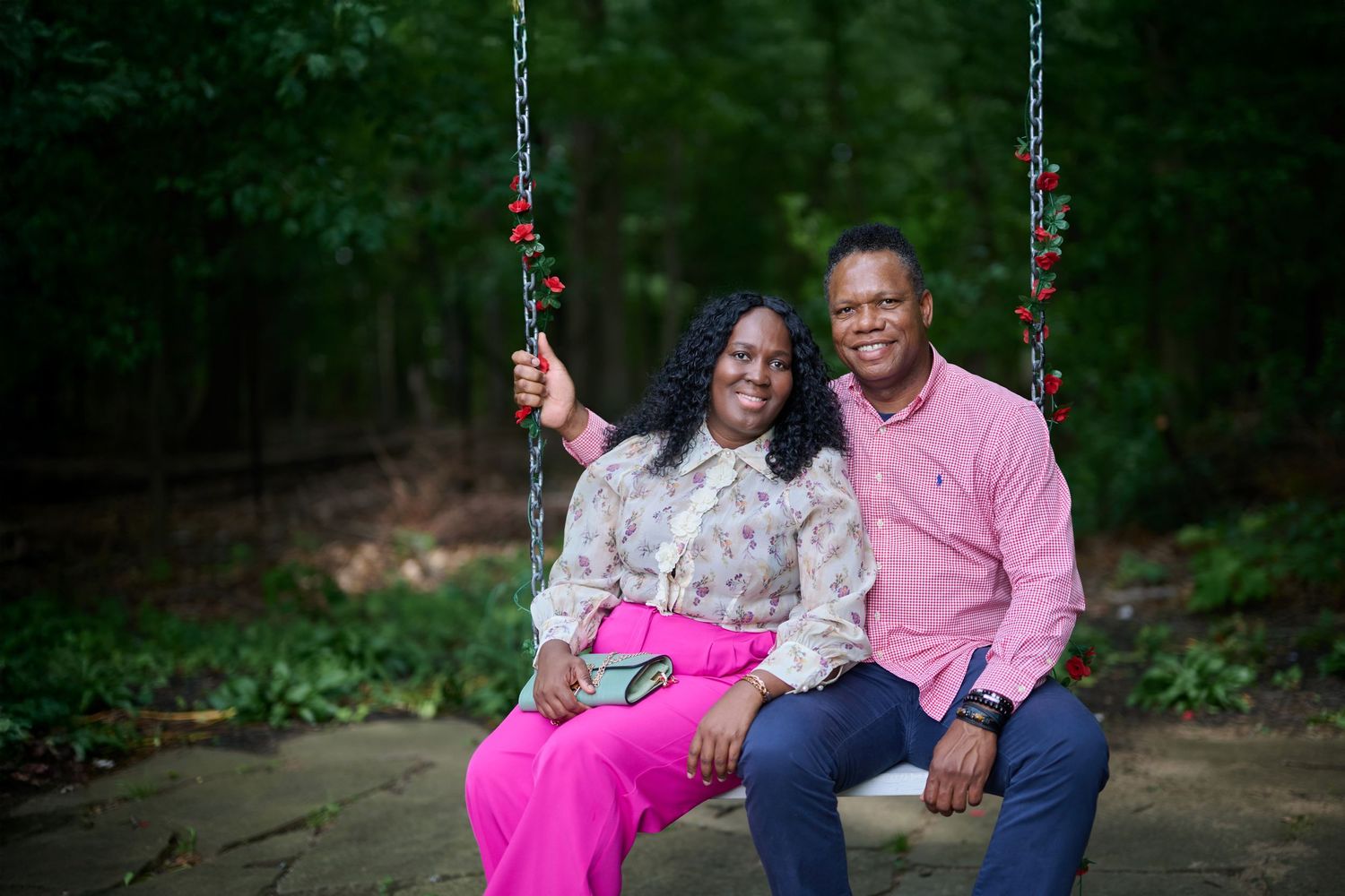 Romantic photoshoot on a stone path with swing set in a forest backdrop.