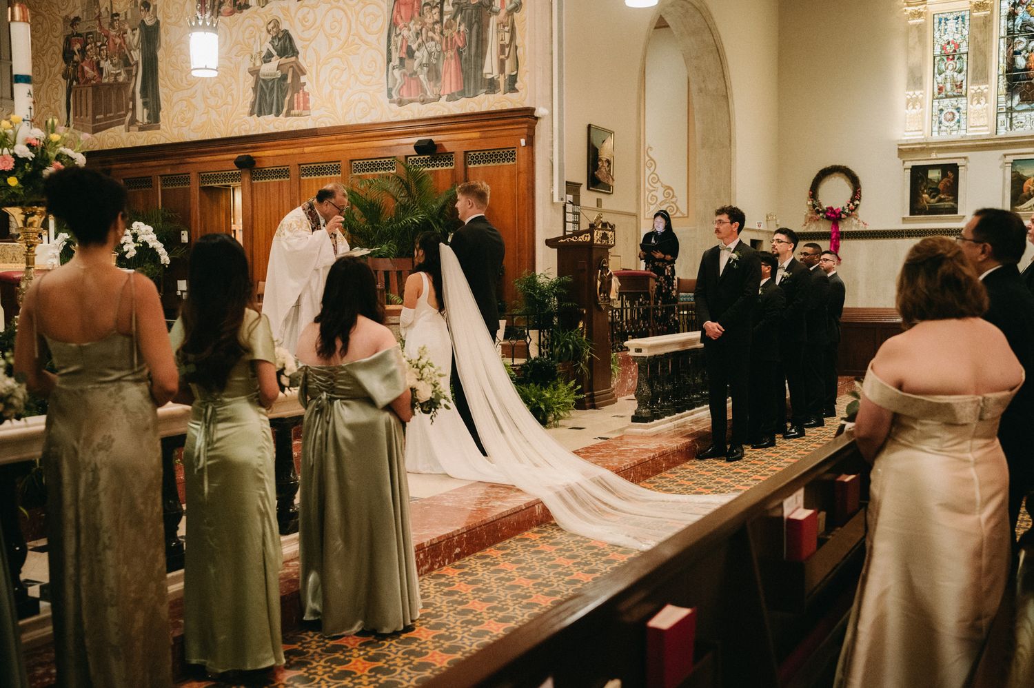 Elegant church wedding ceremony with bride in white gown, bridesmaids in sage green dresses, and groomsmen at the altar.