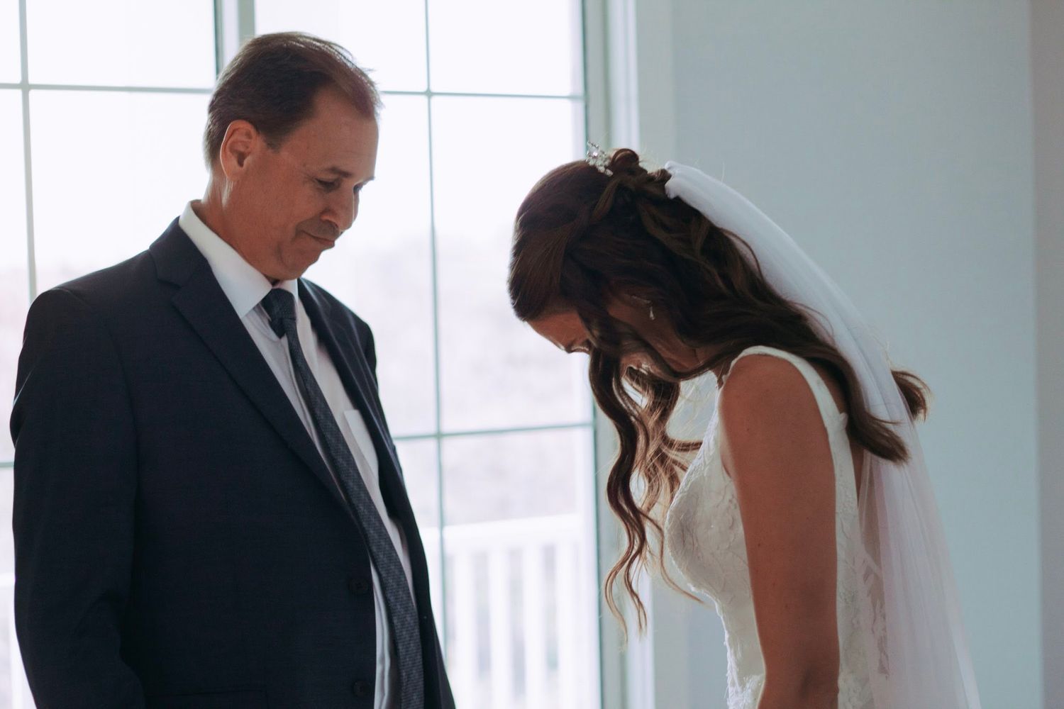 Emotional father and bride sharing a quiet moment together before walking down the aisle.