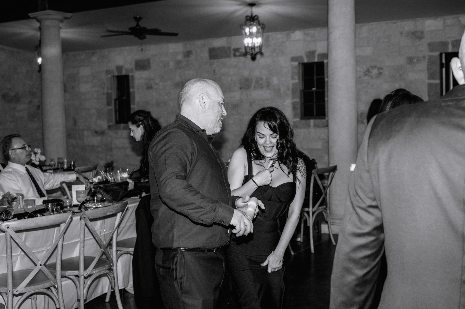 Couple dancing together in black and white photo at elegant wedding reception venue.