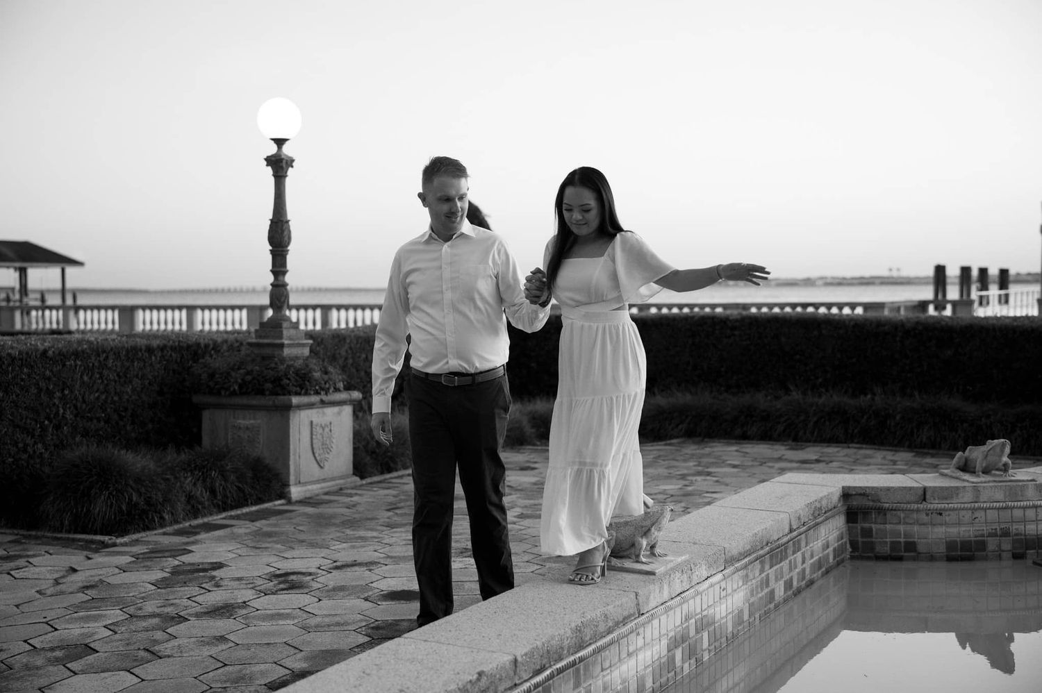 Natural documentary-style elopement photography of a bride and groom walking by a reflection pool in St. Augustine.