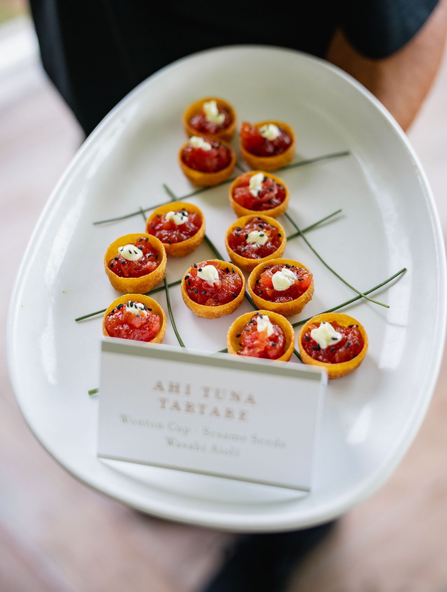 Elegant appetizers of ahi tuna tartare served on white plates with garnish.