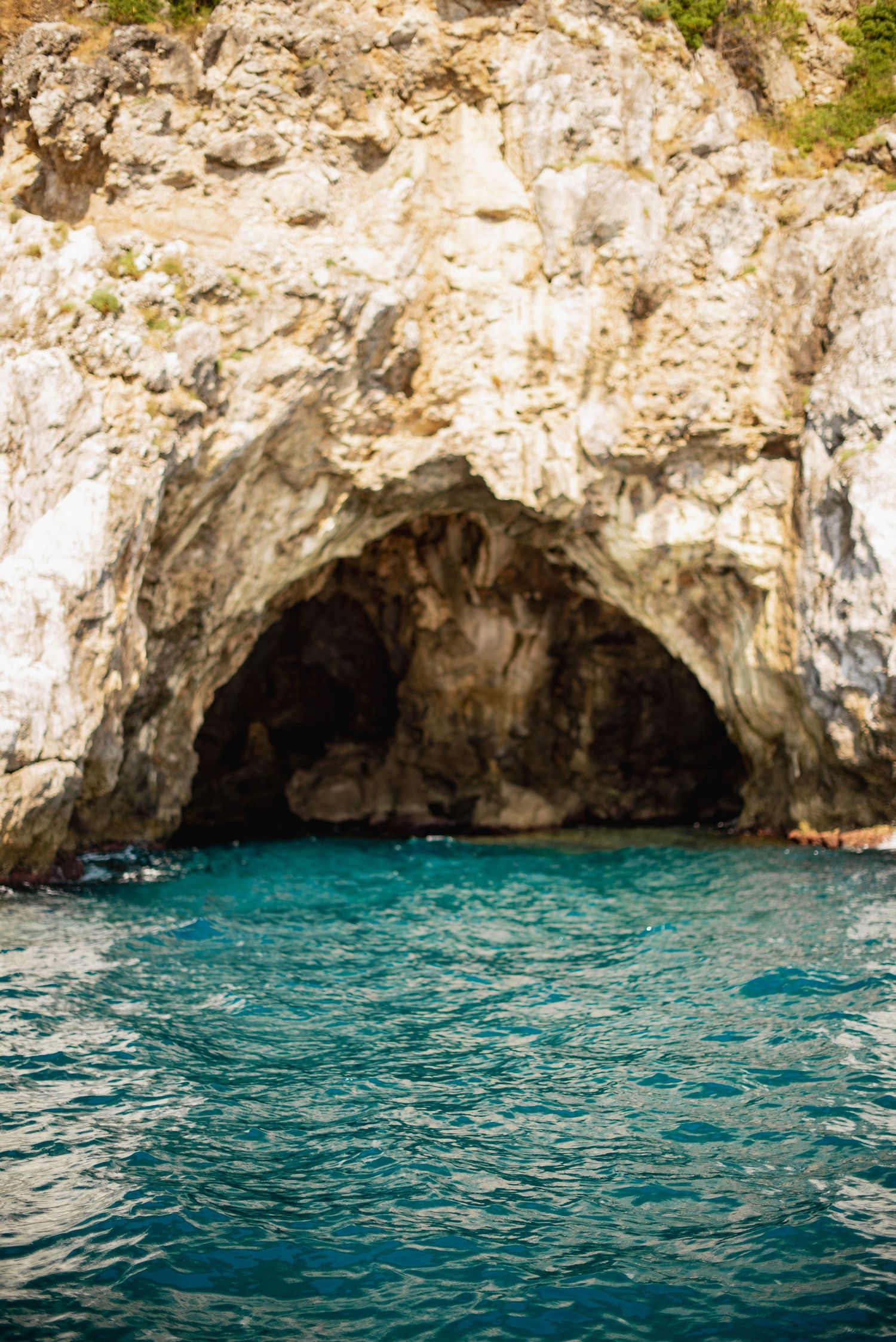 Sardinia photographer - Natural sea cave with turquoise waters and limestone cliffs along Mediterranean coastline.