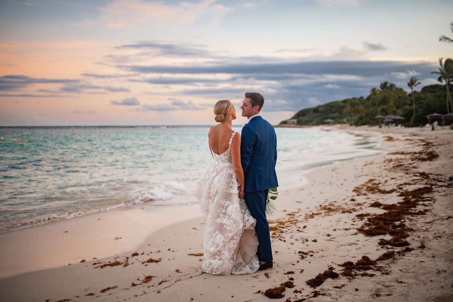 Sunset beach wedding photography session with couple walking along shoreline.