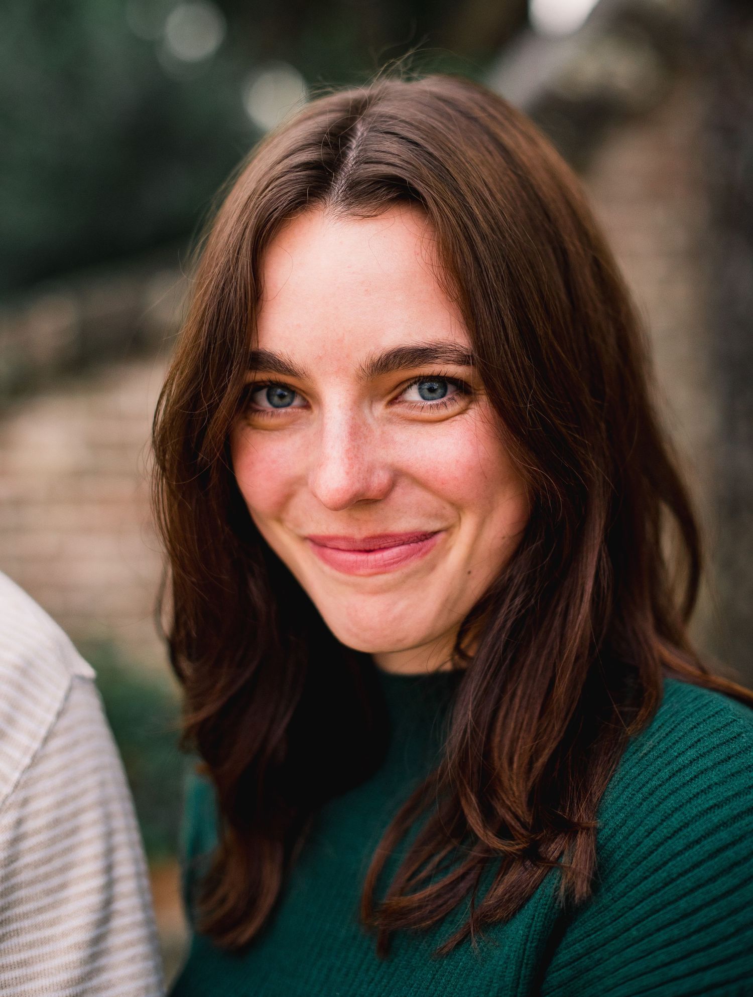 A sequence of five portrait photos showing someone with brown hair making increasingly playful smiling expressions.
