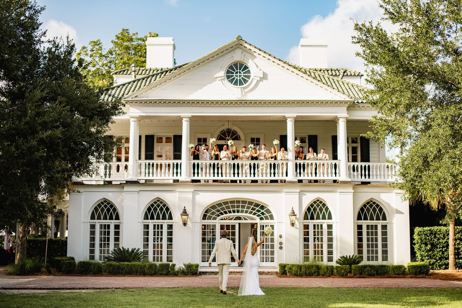 Elegant white Southern plantation-style mansion with grand columns and wrap-around porch showcased from multiple angles.