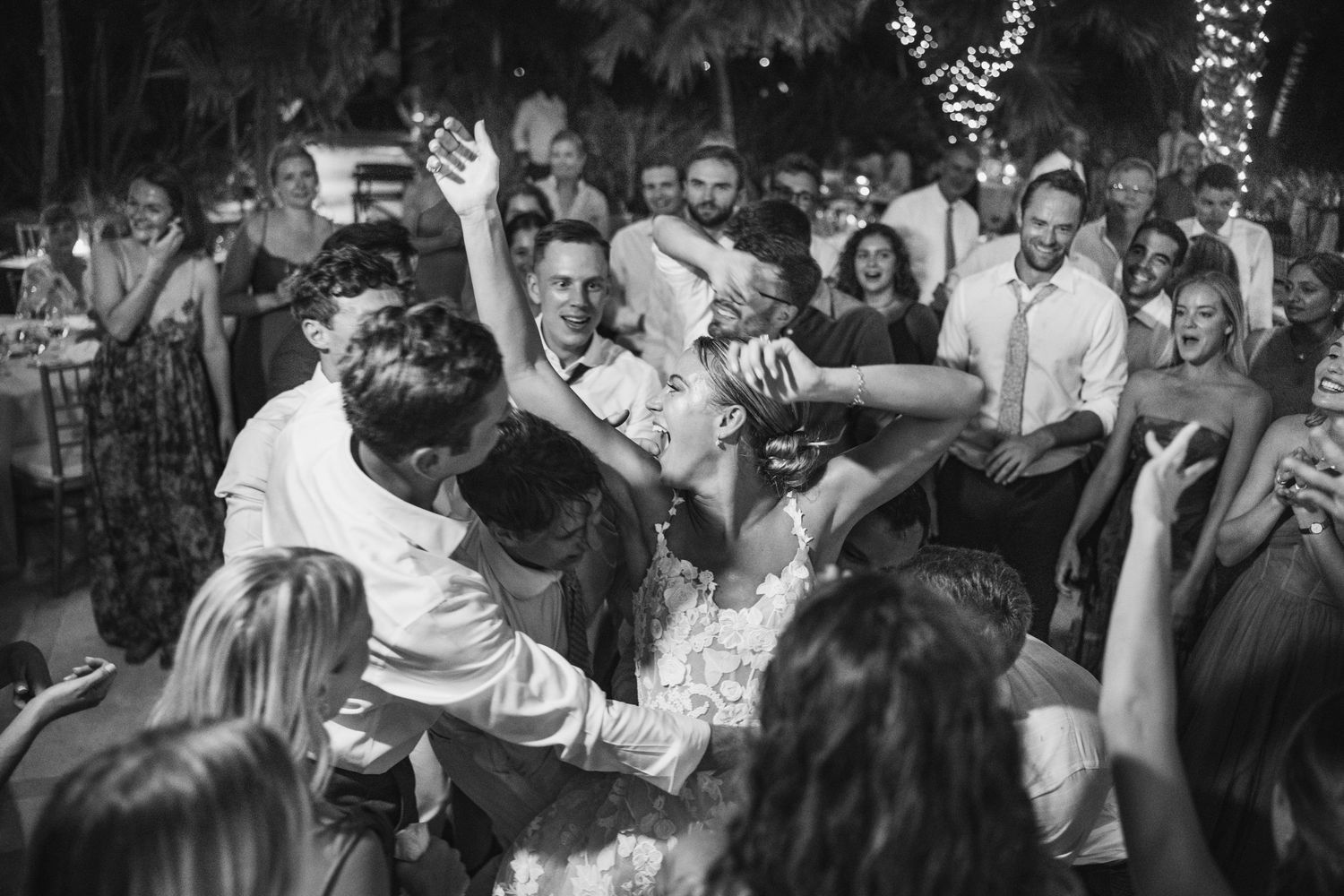 Energetic dance party celebration with crowd gathered under evening lights.
