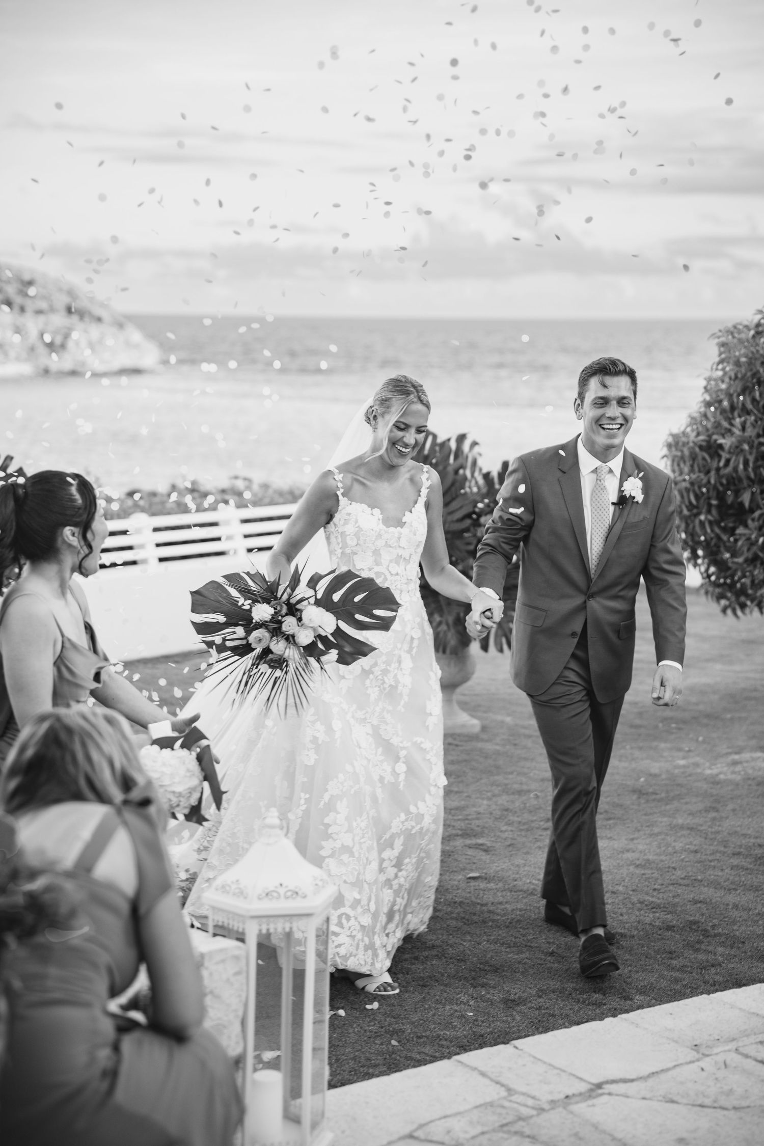 Wedding celebration with confetti flying through the air at an oceanfront venue.