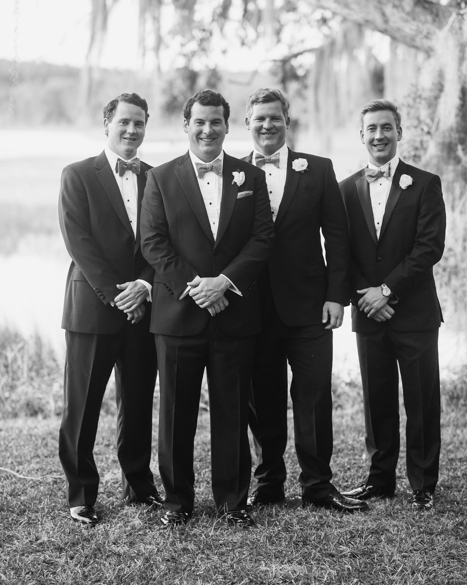 Black and white photo of groomsmen crouched down in matching suits for a creative wedding portrait.