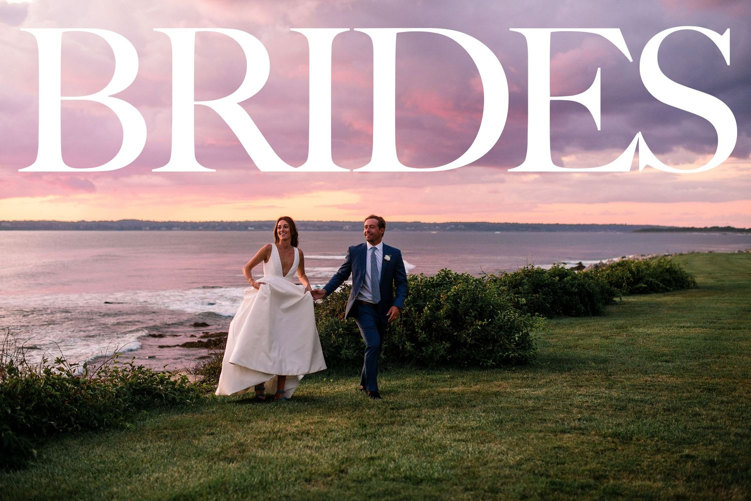 A couple in wedding attire walks along a scenic coastal cliff at sunset, creating a romantic silhouette.
