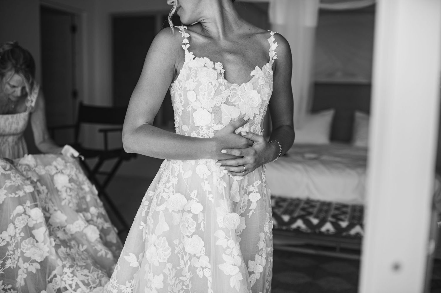 Elegant lace wedding dress detail shown in black and white photography.