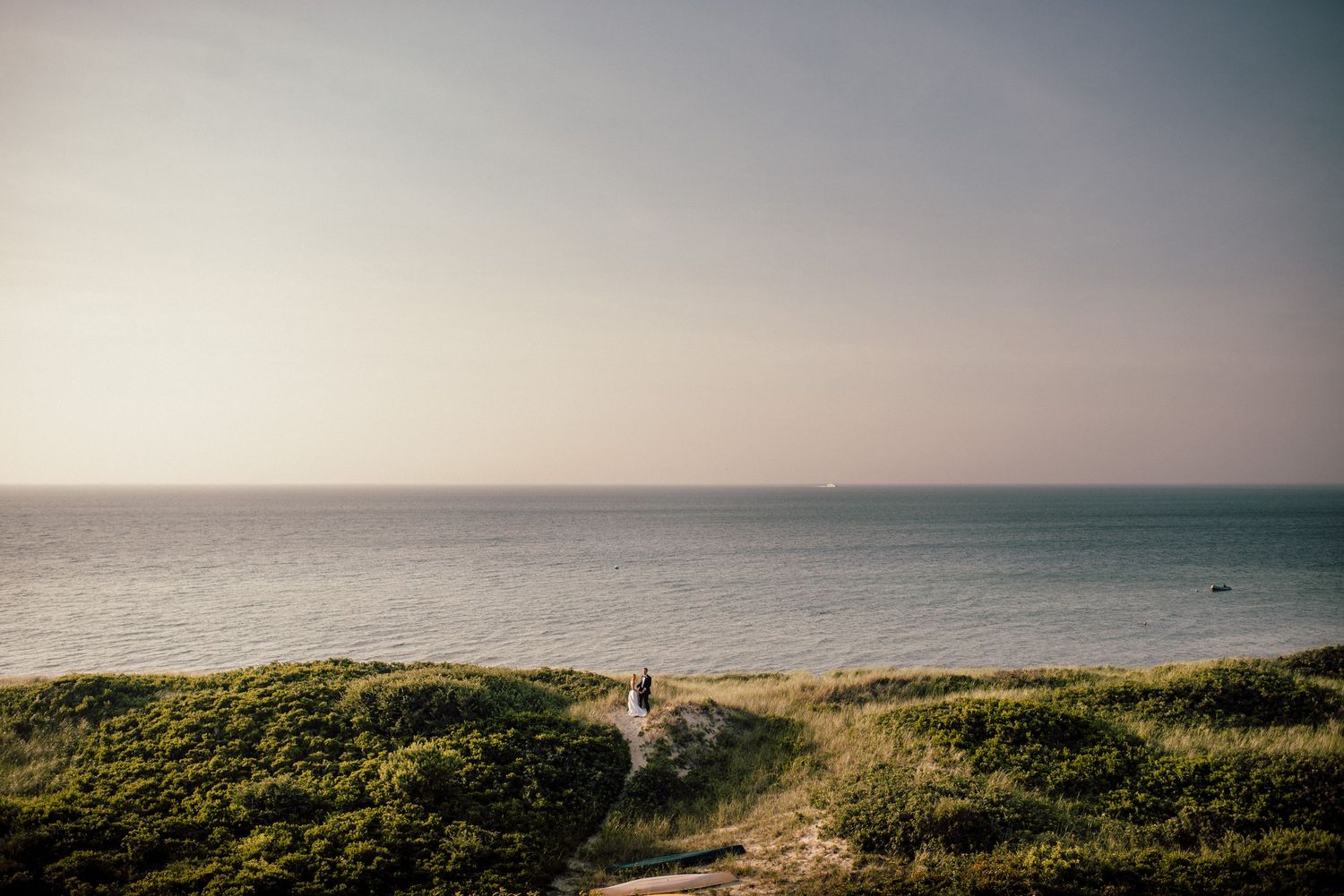 Coastal landscape panorama with rolling green hills and misty ocean views at sunset creating a serene atmosphere.