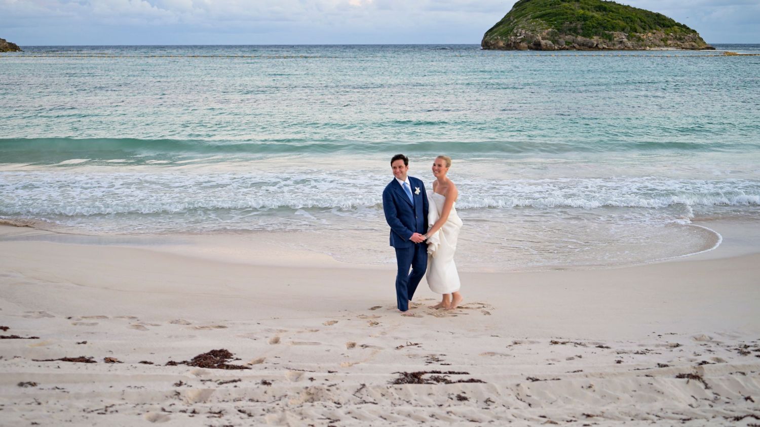 Scenic beach wedding photos with small island visible in the distance.