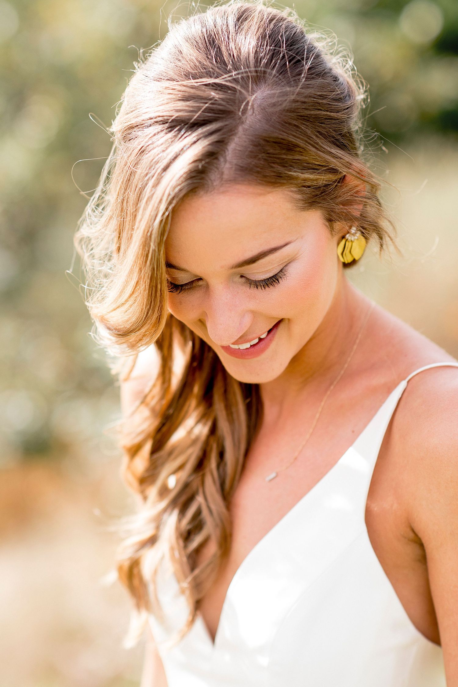 Close-up portrait shots of a bride with flowing hair in natural sunlit setting.
