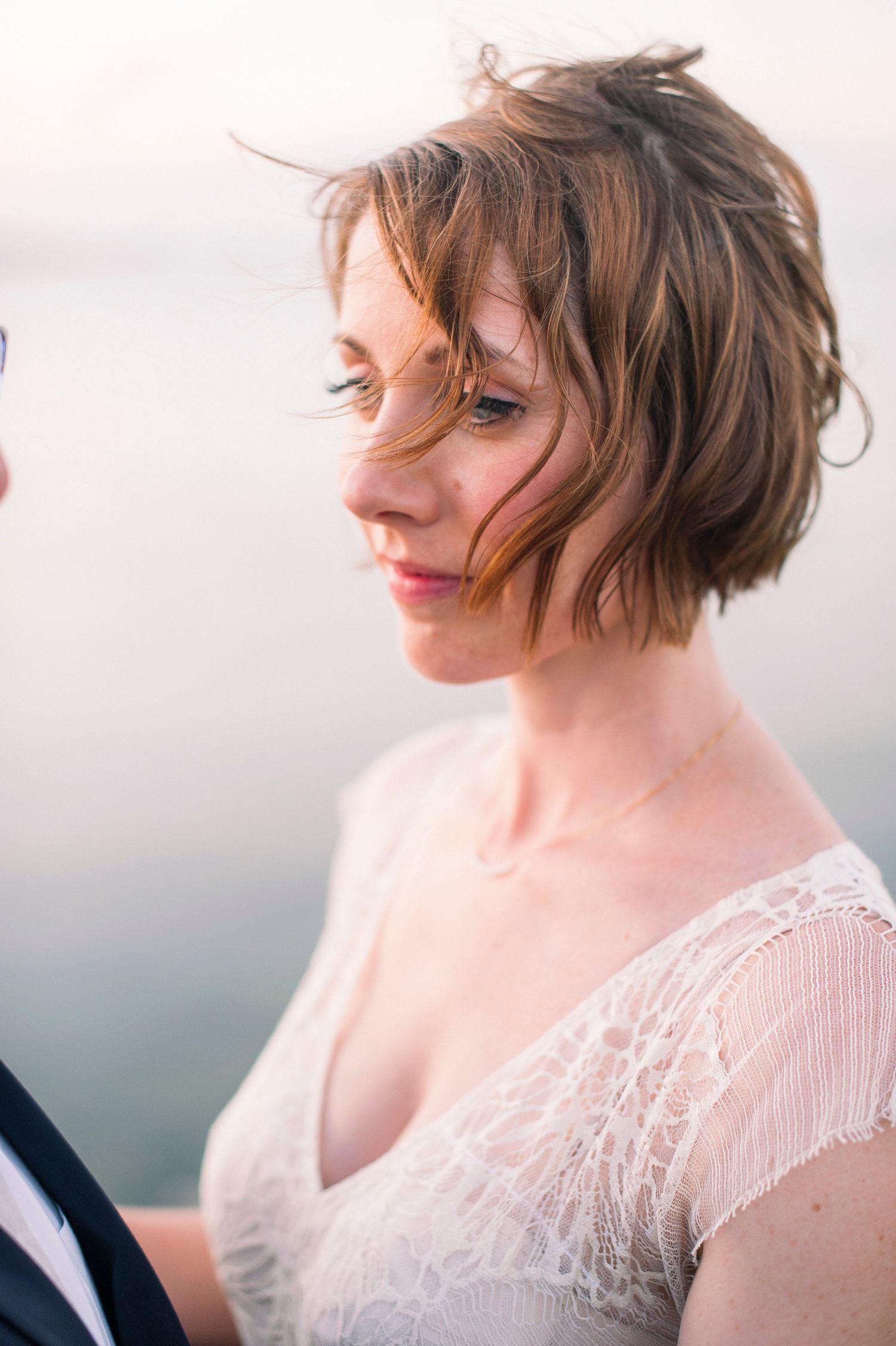 Romantic lace wedding dress details captured in soft natural light.
