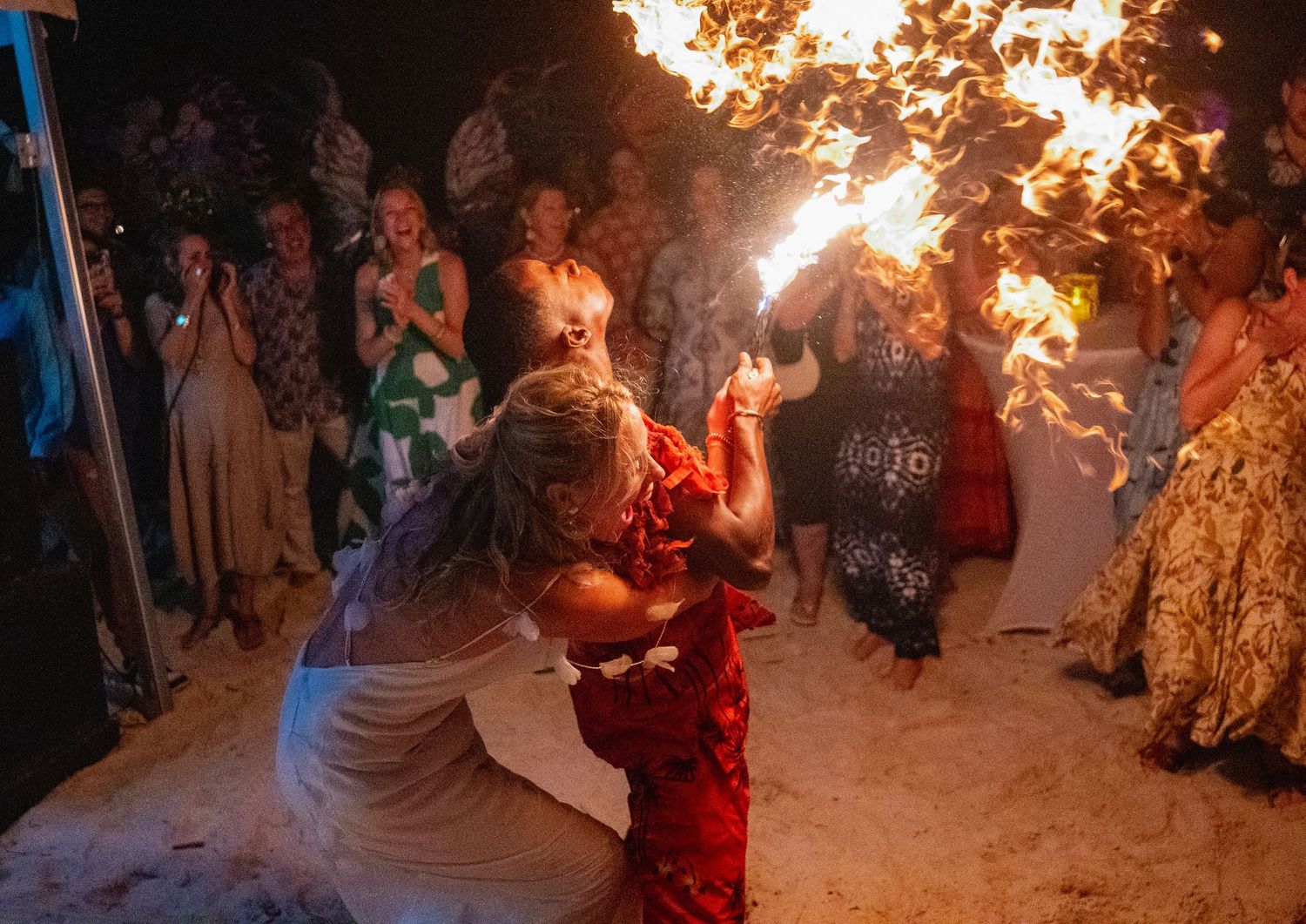 Wedding guests hold sparklers creating a glowing tunnel of light during an evening celebration.