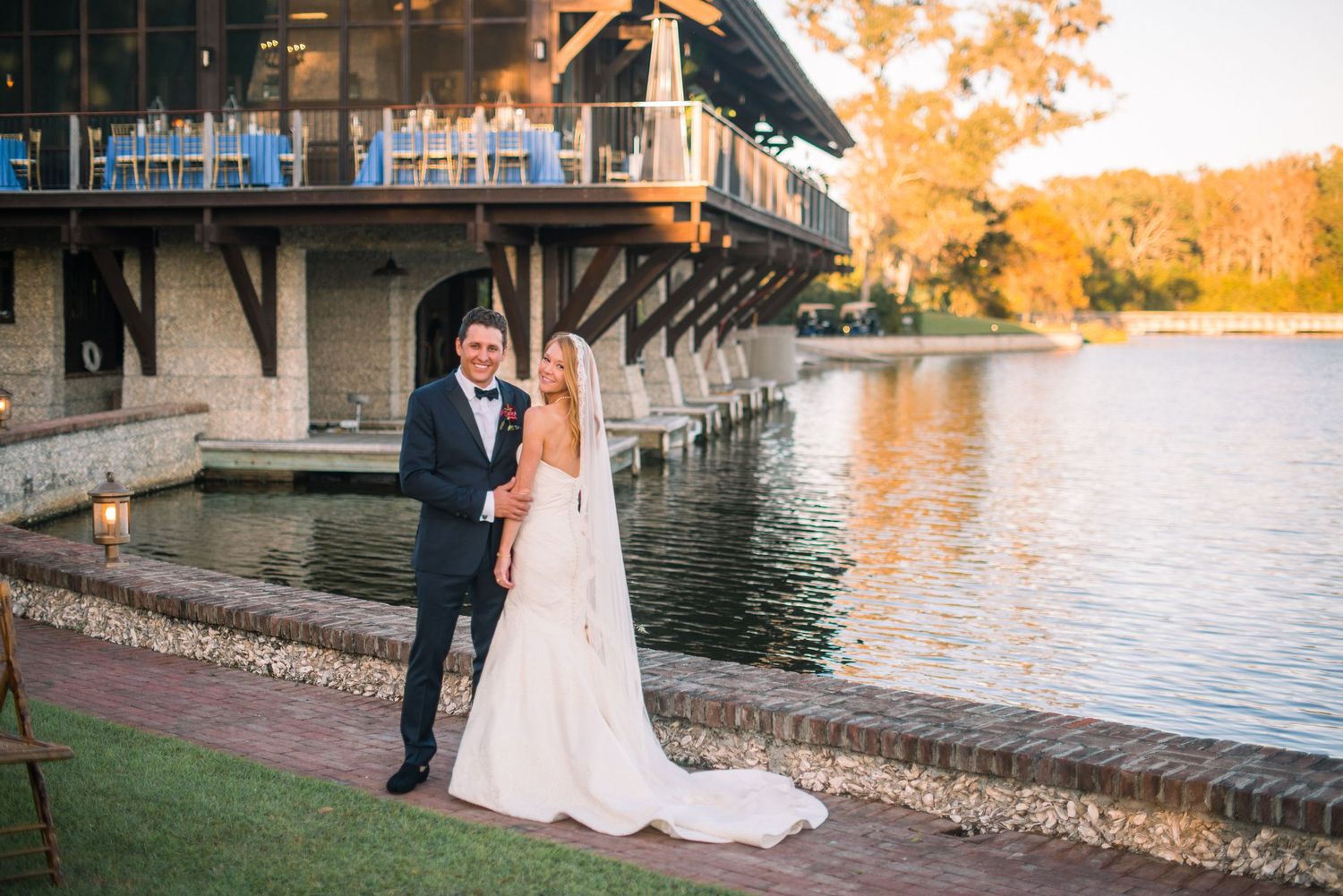 Scenic lakeside wedding venue at sunset with golden autumn colors reflecting on the water.