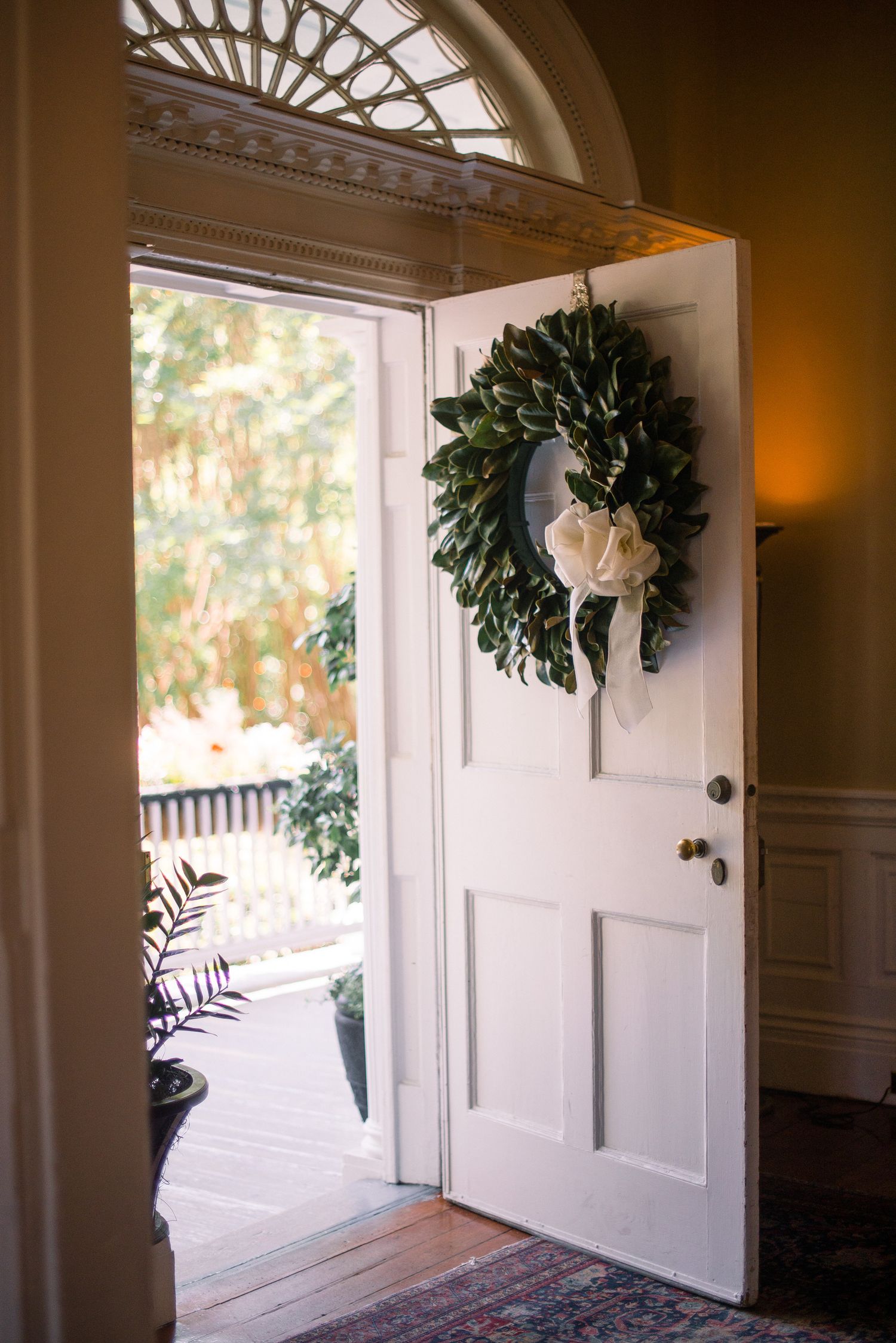 A series of white front doors with decorative wreaths and architectural details in a residential hallway.