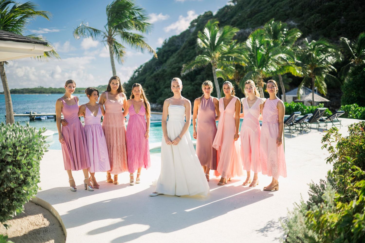 Wedding party in pink dresses posing on a tropical beach.