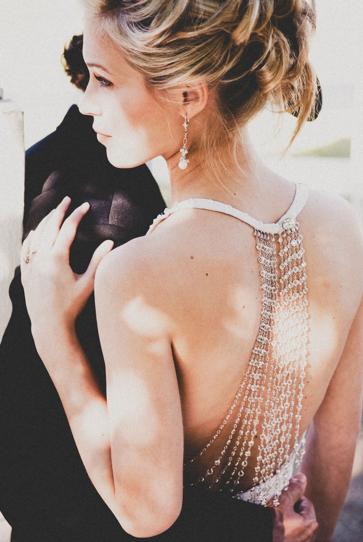 Glamorous bridal portrait showcasing intricate crystal back detail on a formal gown.