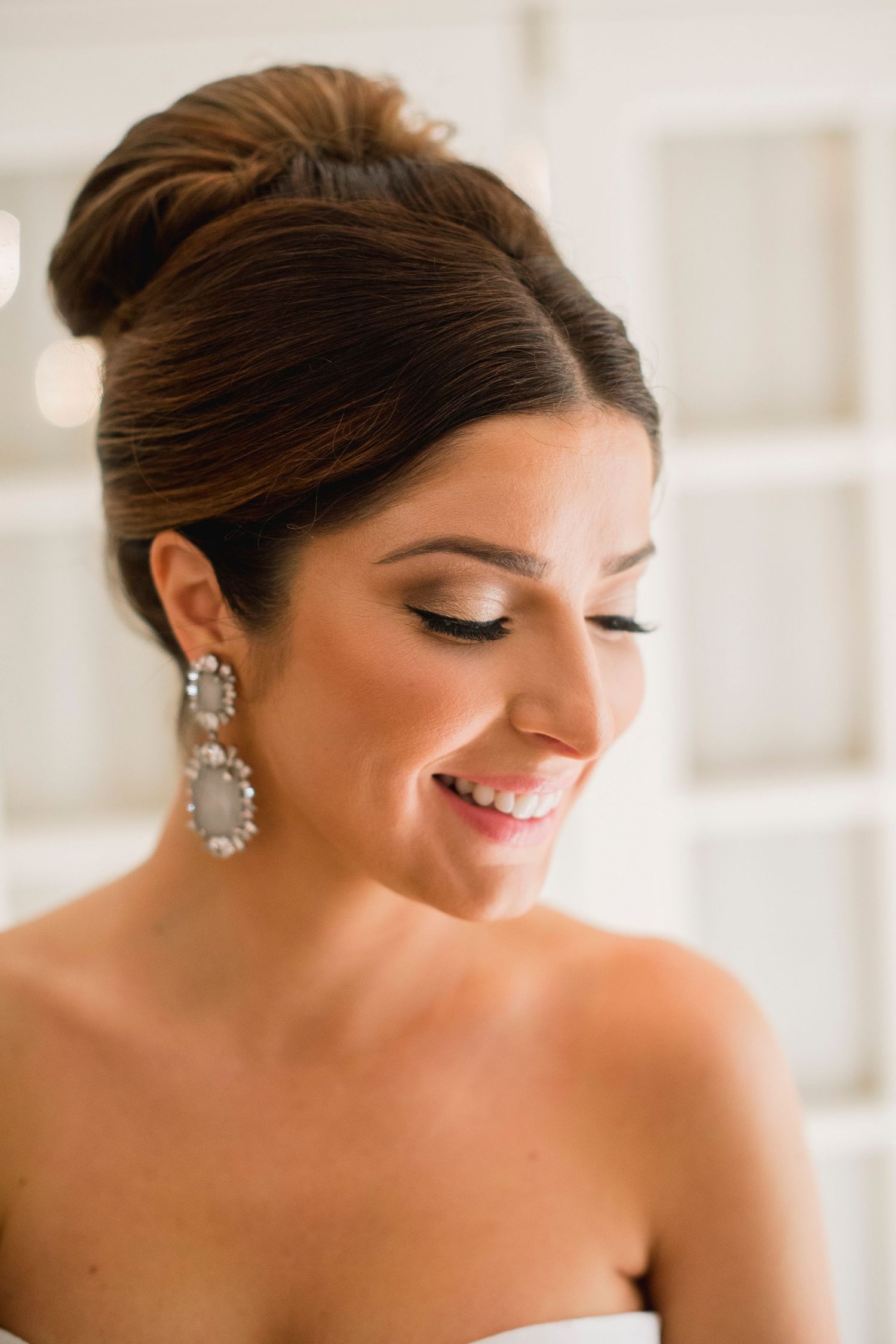 Close-up portrait showcasing elegant bridal makeup and sparkling drop earrings.