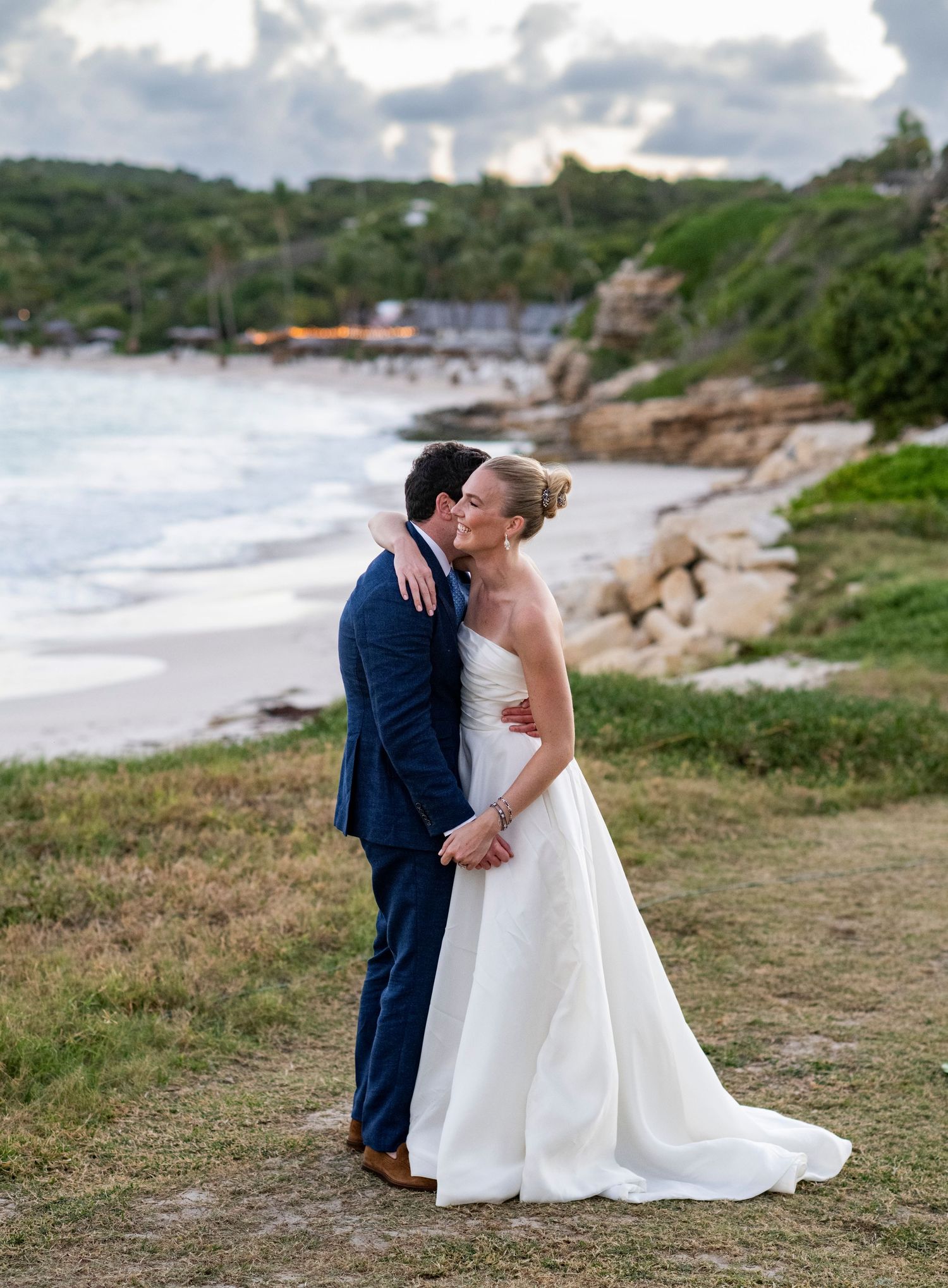 Romantic wedding portraits captured on a scenic coastal hillside overlooking the ocean.