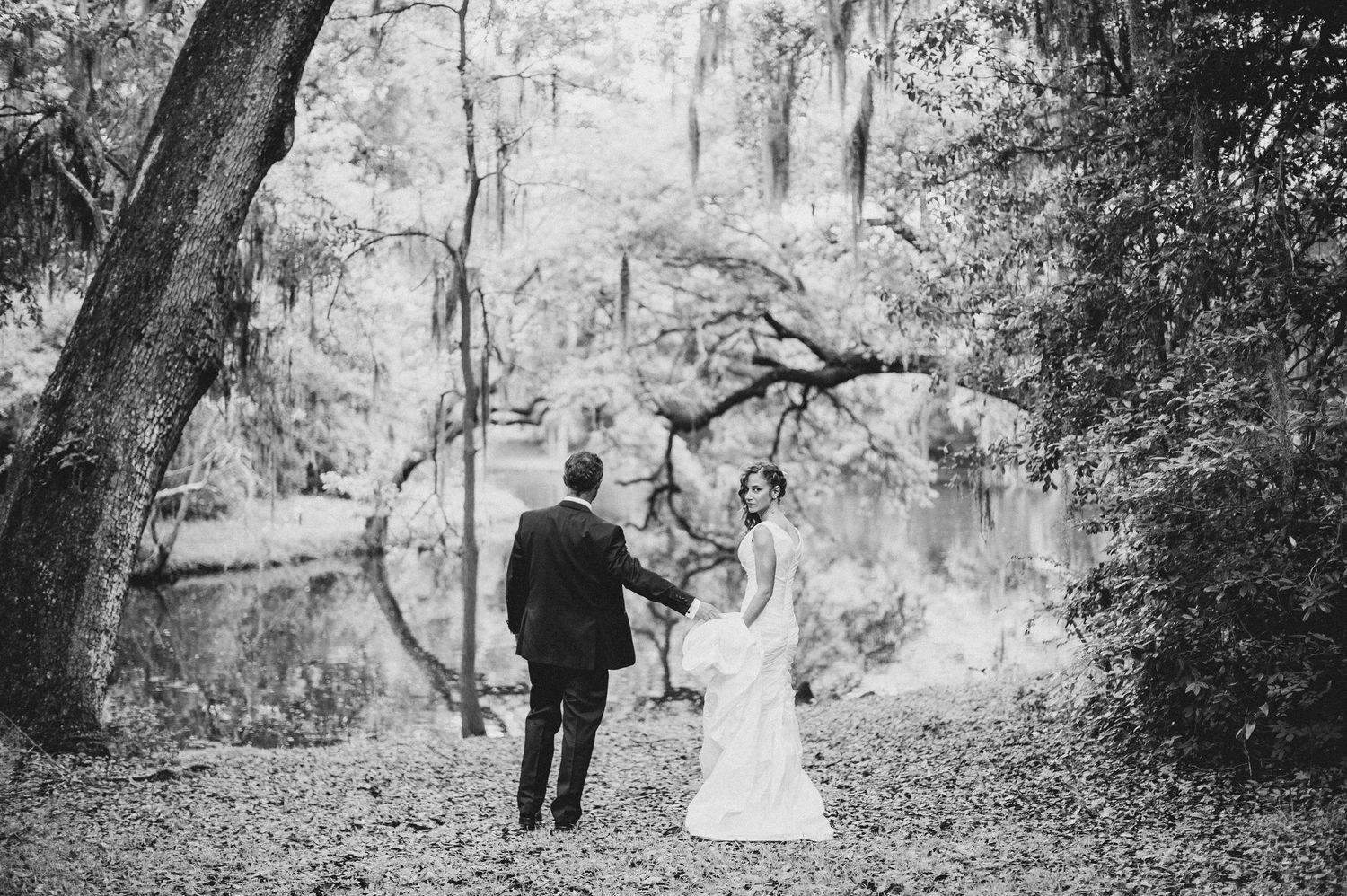 Black and white wedding photos of a couple posing together in a scenic wooded outdoor setting.