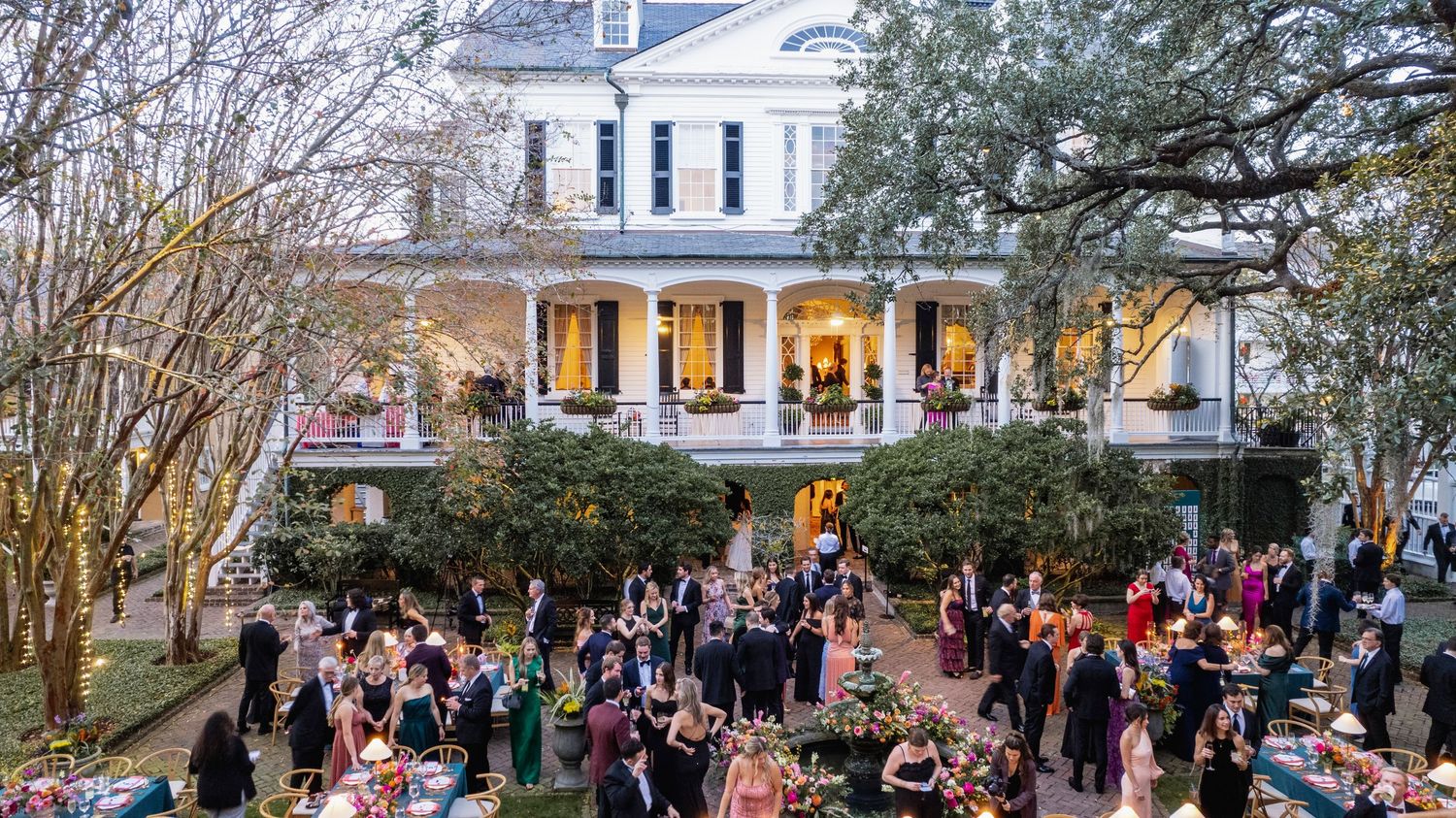 A crowd of people gathered outside historic buildings during a springtime event or celebration.