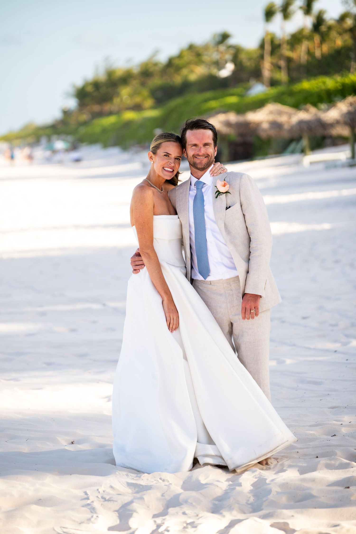 Newlyweds share intimate moments on a pristine white sand beach during their destination wedding.