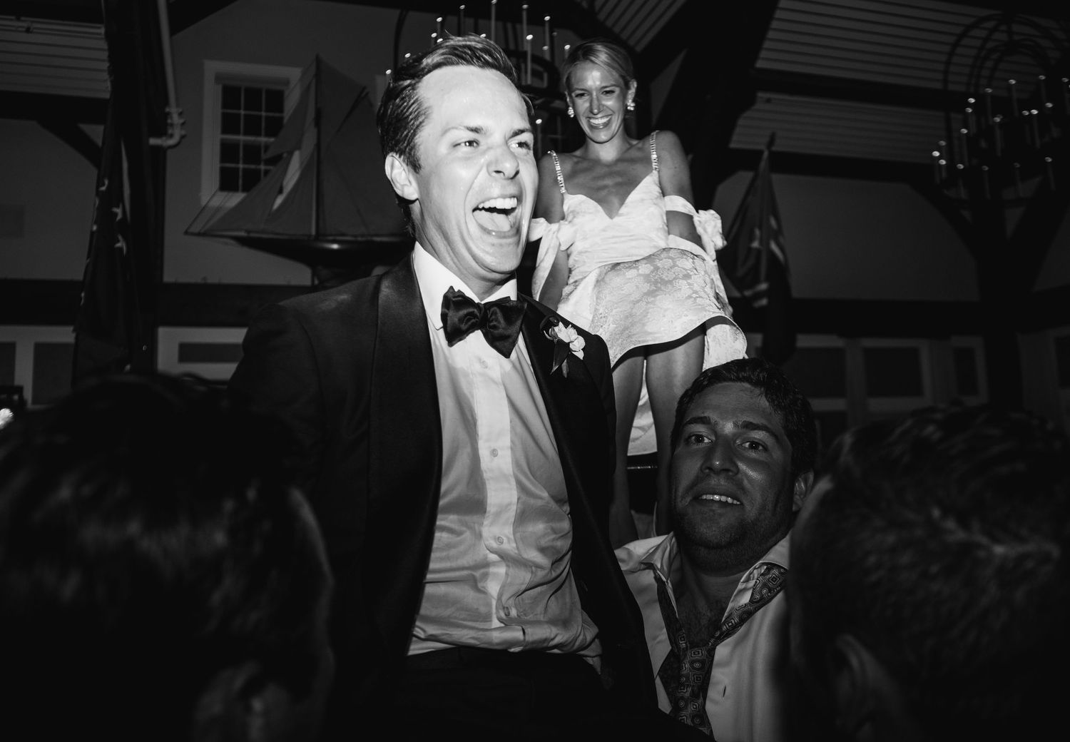 Black and white photos of wedding guests laughing and celebrating on the dance floor.