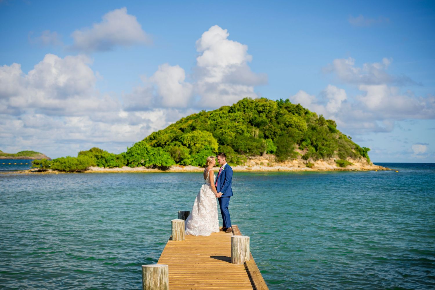 Scenic tropical beach views with turquoise waters, wooden docks, and lush green islands under blue skies.