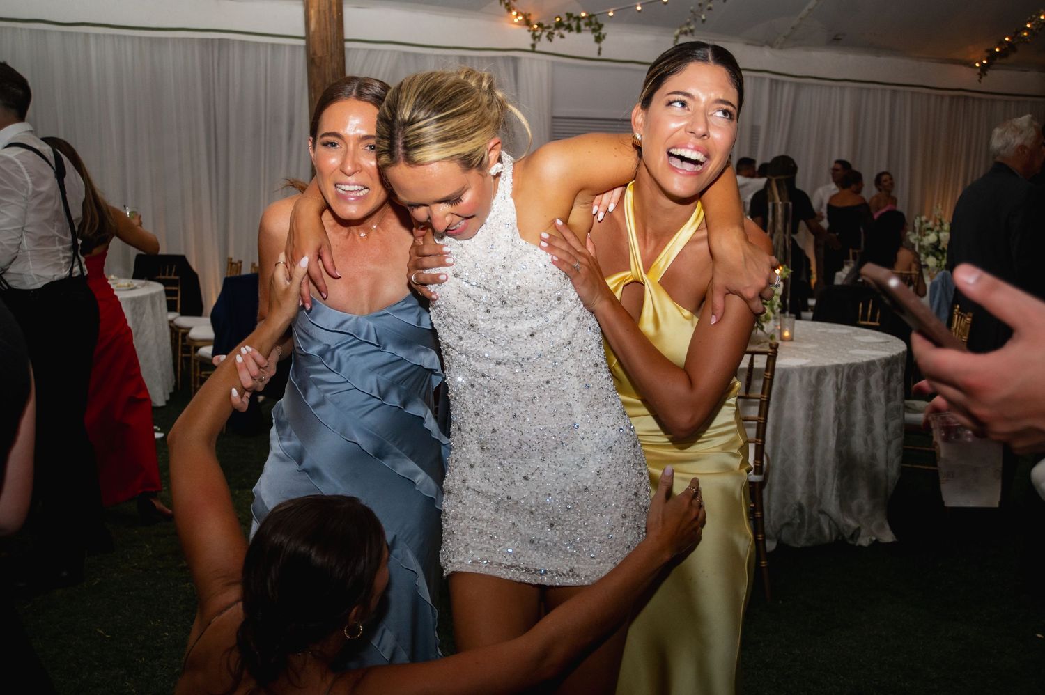 Wedding party dancing and celebrating at indoor reception.