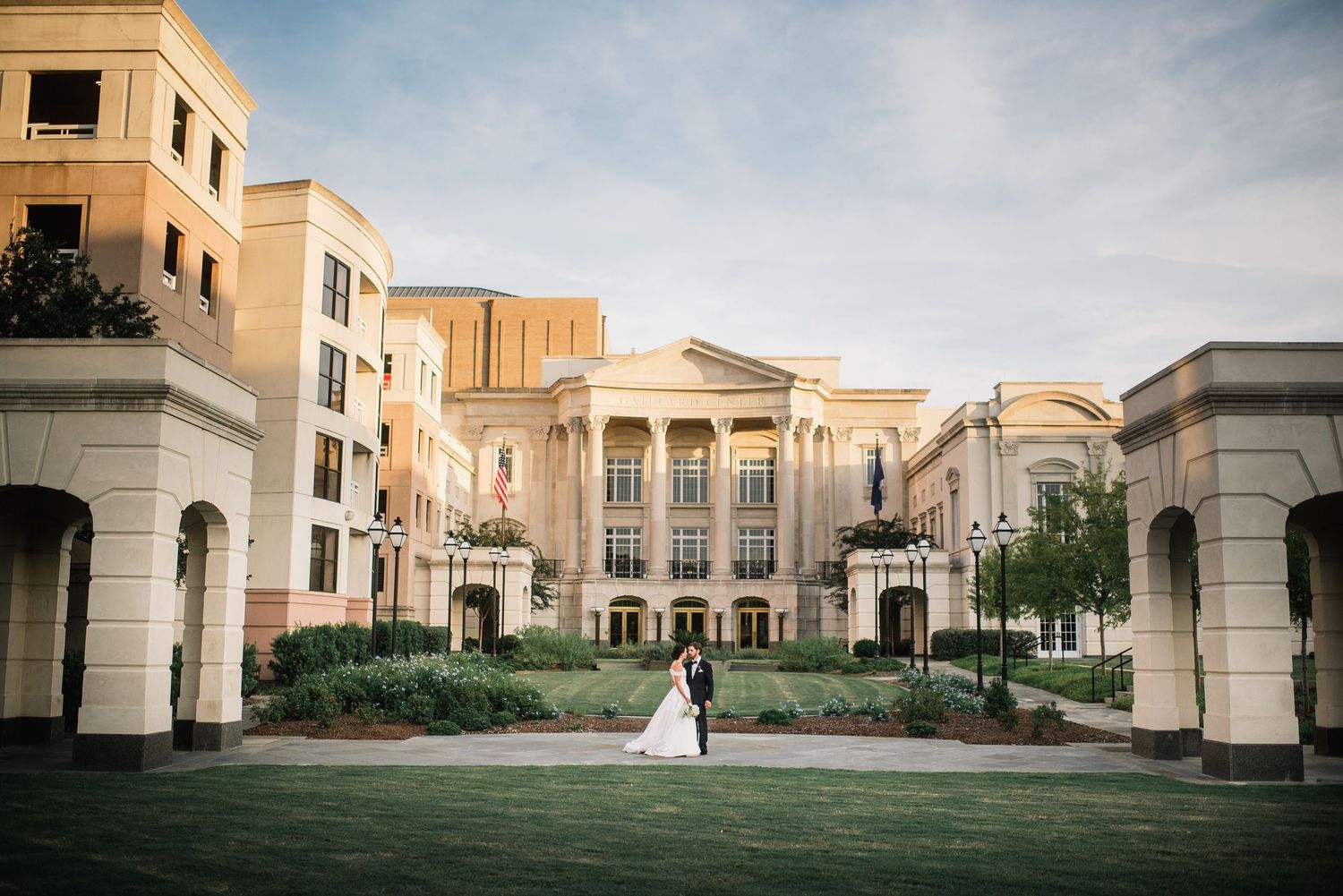 Panoramic view of Mediterranean-style architecture with arched walkways and courtyards at golden hour.