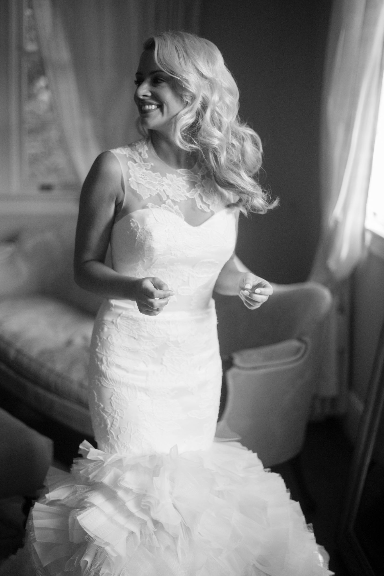 Black and white photos of a bride in a flowing white wedding dress getting ready.