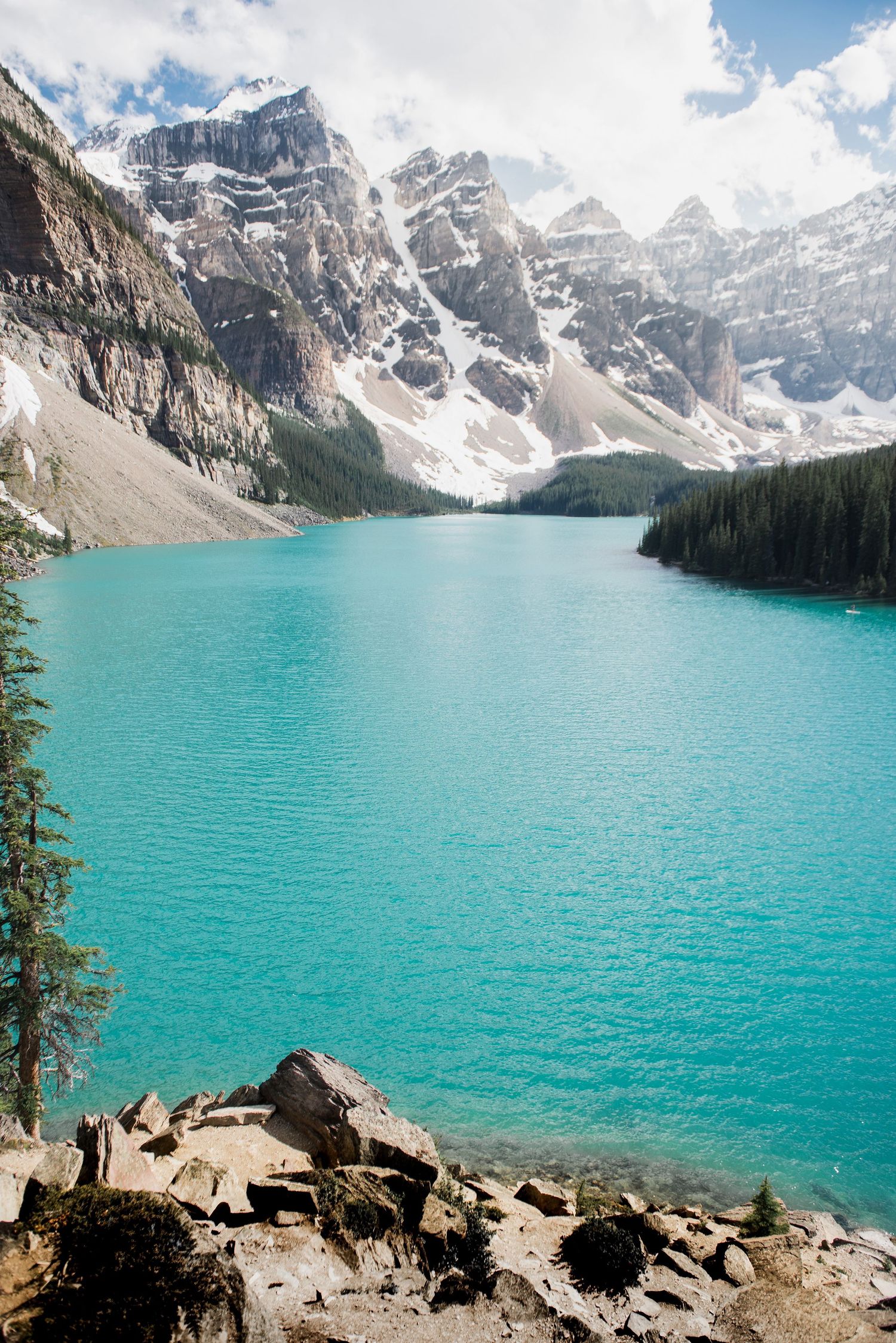 Stunning turquoise waters of Moraine Lake surrounded by snow-capped Rocky Mountain peaks in Banff National Park.