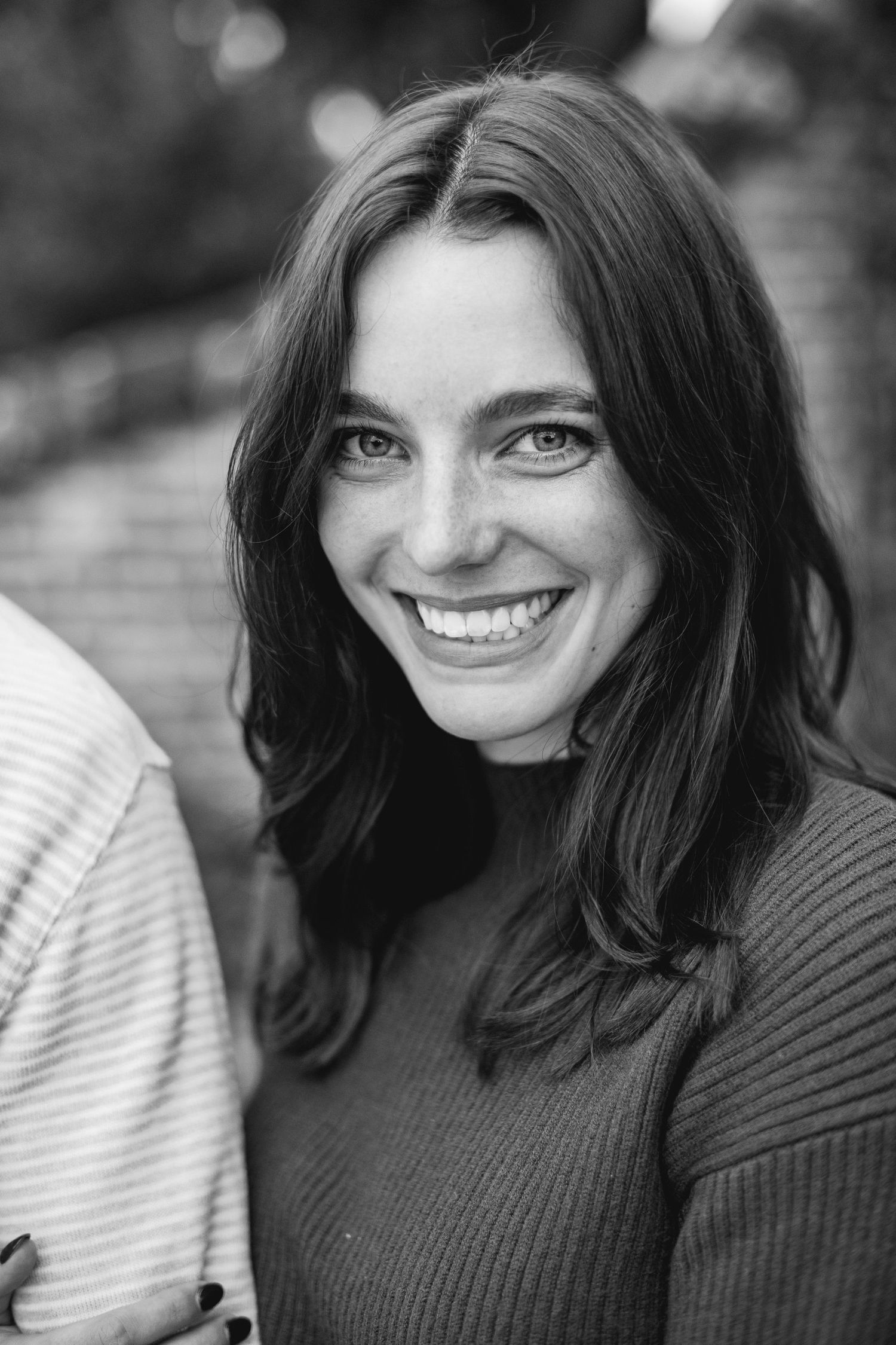 Black and white portrait series showing joyful expressions and genuine laughter in a casual sweater.