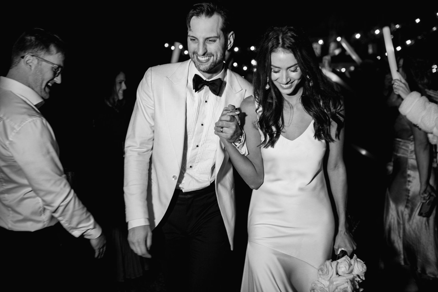 A black and white photo collage of a wedding celebration showing dancing and joyful moments at an evening reception.