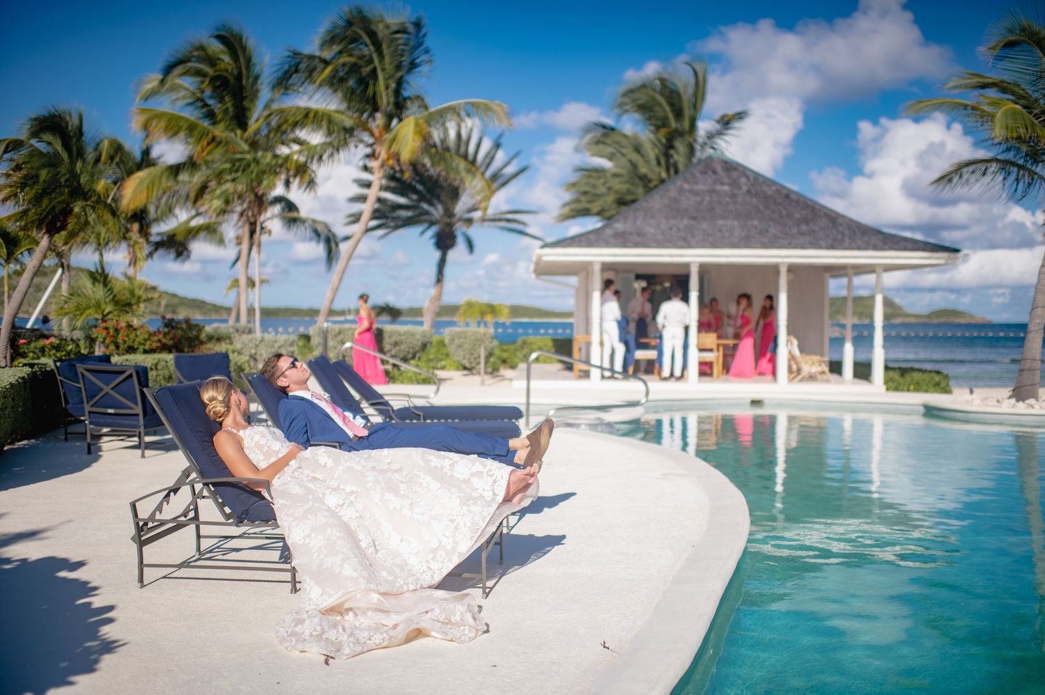 Luxurious poolside setting with lounge chairs and oceanfront gazebo at a tropical resort.